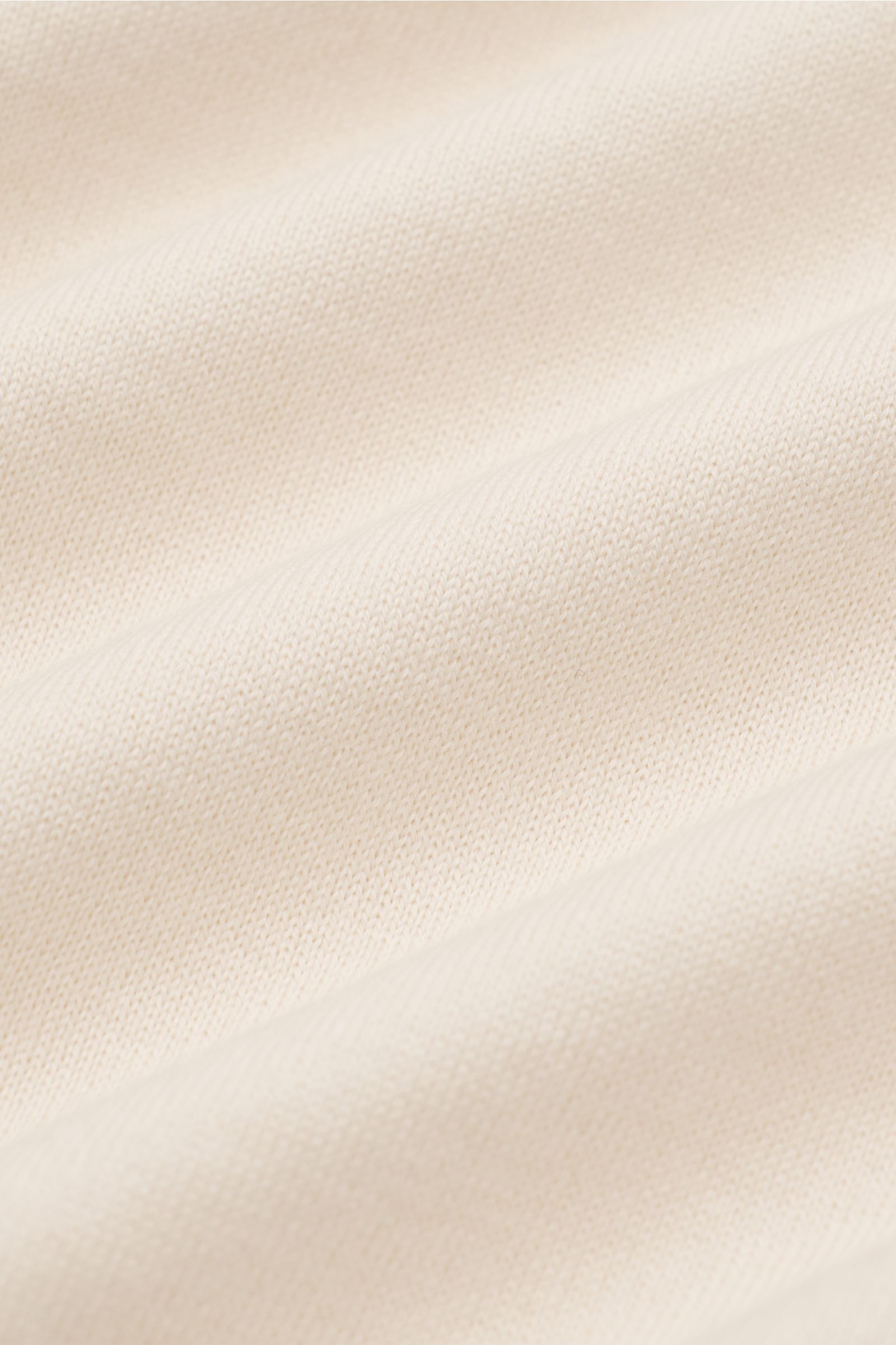 Brunello Cucinelli Kurzarmpullover creme, Nahaufnahme feines Baumwollstrickbild mit schmalen Kontrastkanten, weiche, geschmeidige Textur.