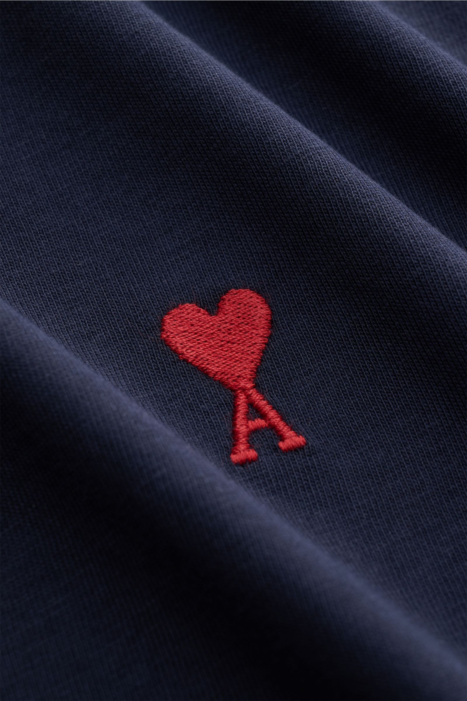 Close-up front view of the Ami Paris Rundhals-T-Shirt navy showing red heart stitching on soft navy cotton jersey fabric.

Klassisches Jersey-Basic vom französischen Label AMI PARIS: Dieses T-Shirt mit Rundhalsausschnitt ist aus reiner Baumwolle gearbe