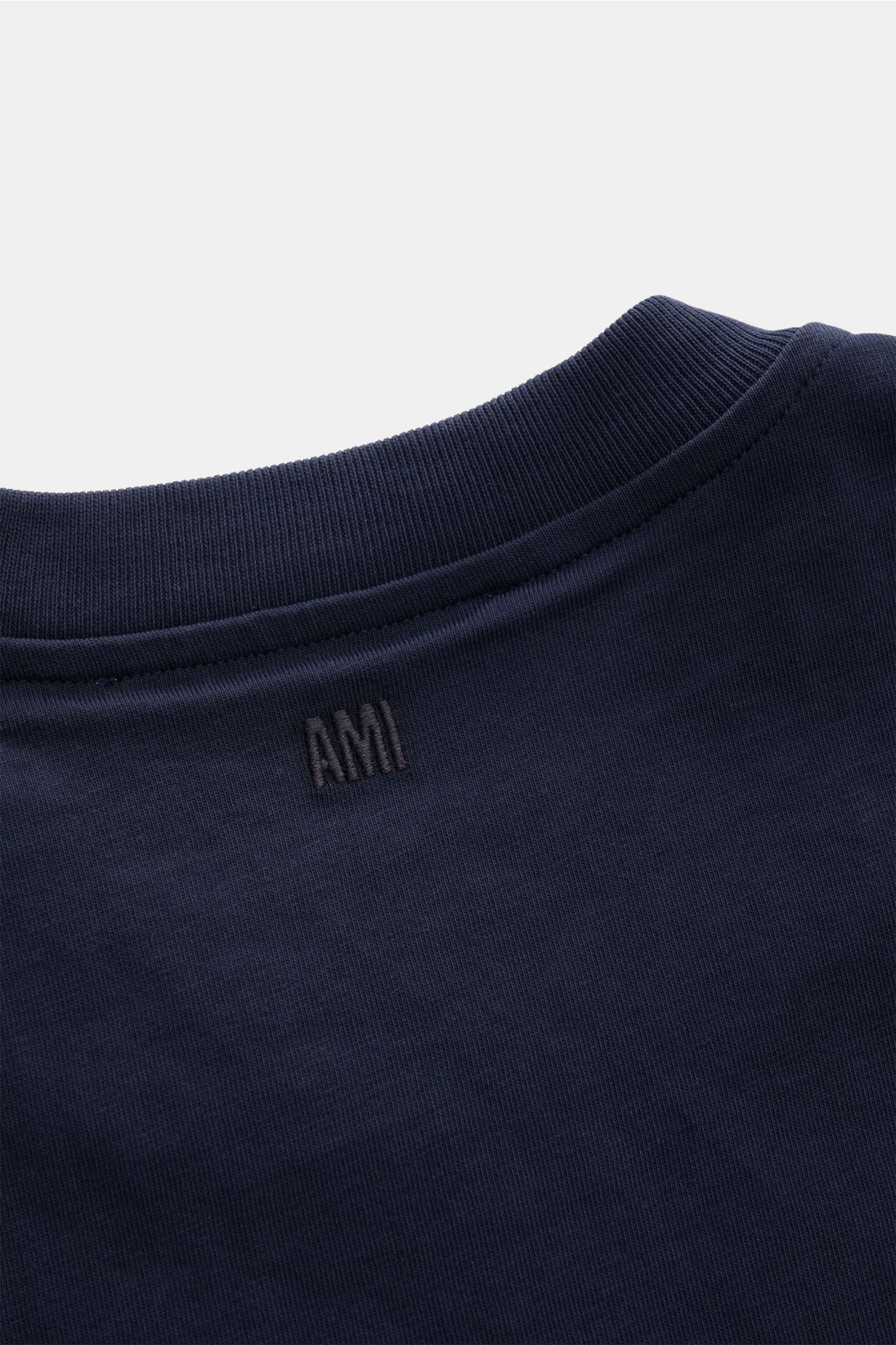 Close-up back view of the Ami Paris Rundhals-T-Shirt navy showing the ribbed round neckline and tonal AMI stitching on soft pure cotton jersey fabric. 

Klassisches Jersey-Basic vom französischen Label AMI PARIS: Dieses T-Shirt mit Rundhalsausschnitt i