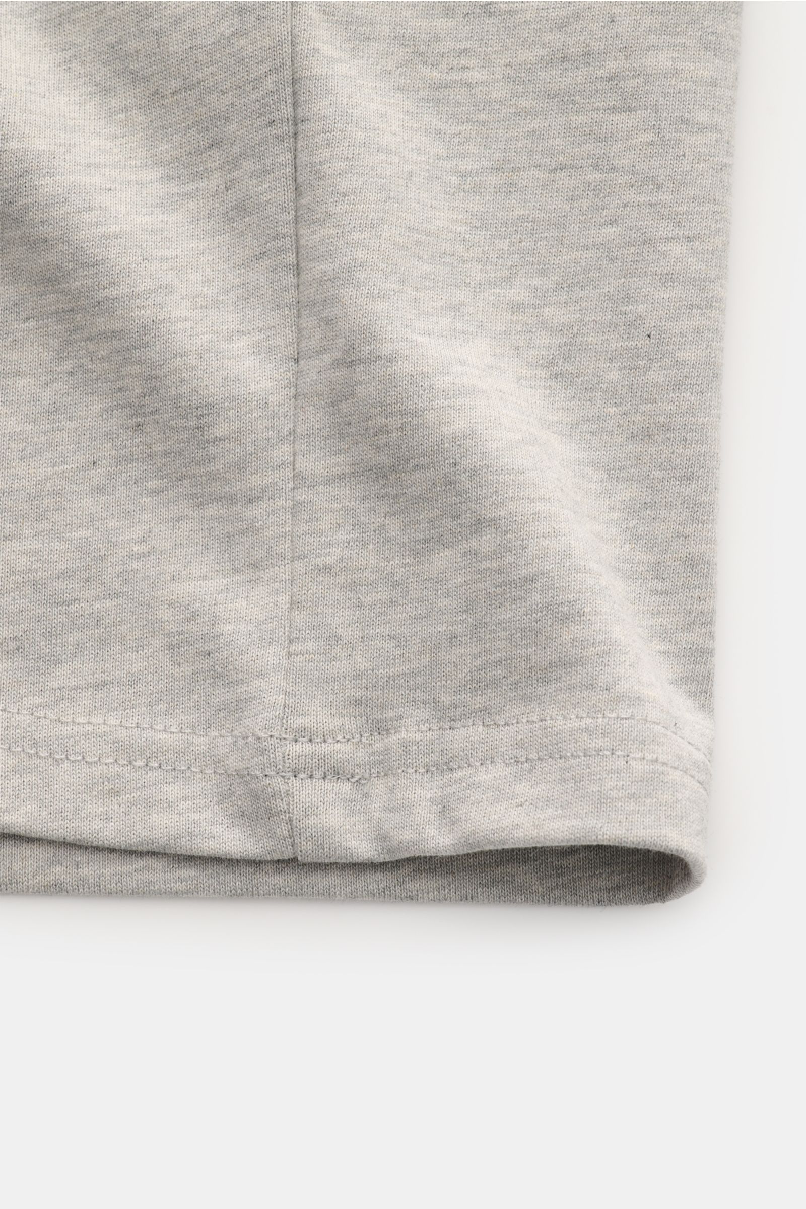 Nahaufnahme der unteren Saumkante eines Ami Paris Rundhals-T-Shirts grau meliert aus schwerem Baumwolljersey mit weichem Griff.