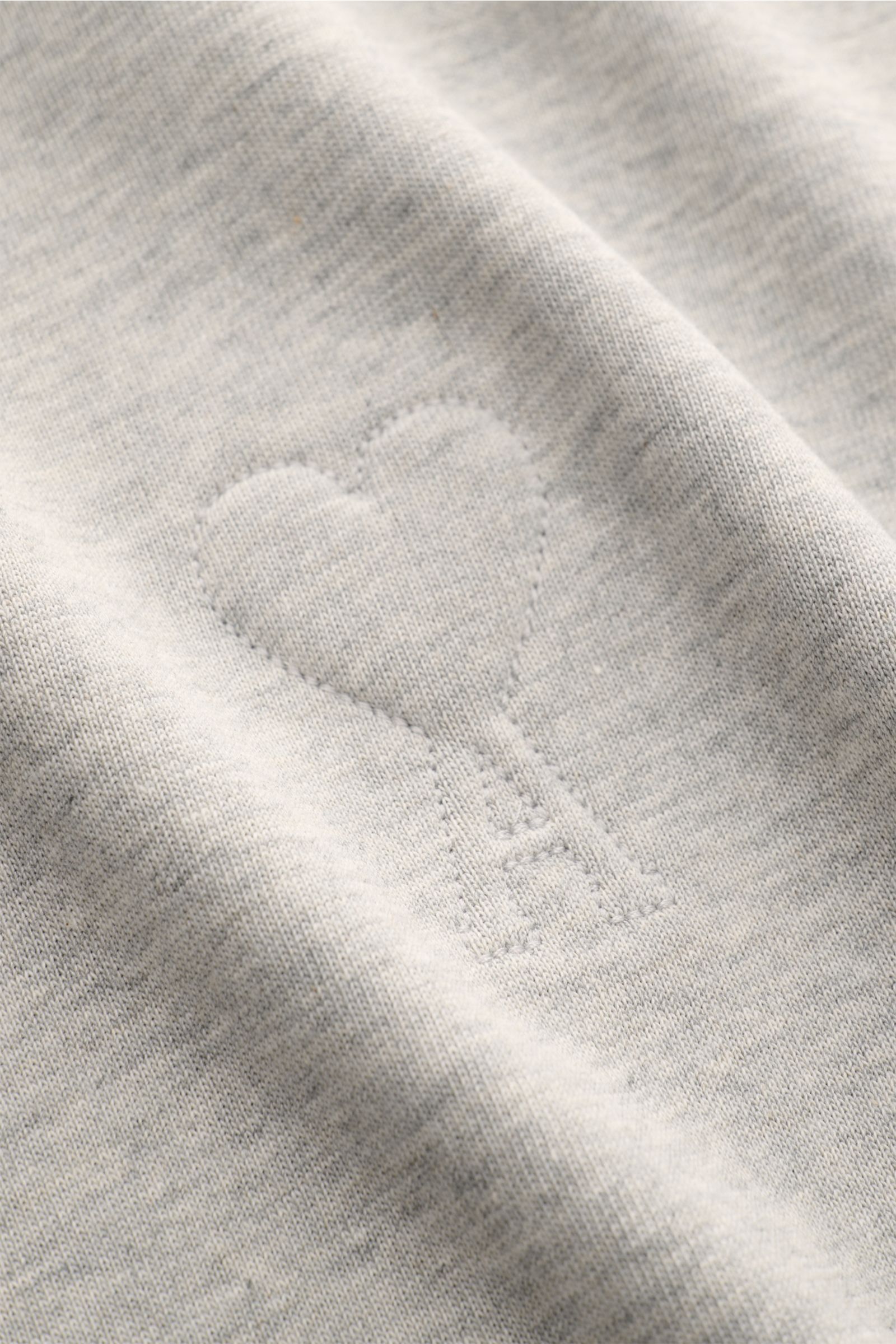 Nahaufnahme des Ami Paris Rundhals-T-Shirt grau meliert mit abgesteppte Herz-Logo, weichem Baumwolljersey und Oversized Fit.