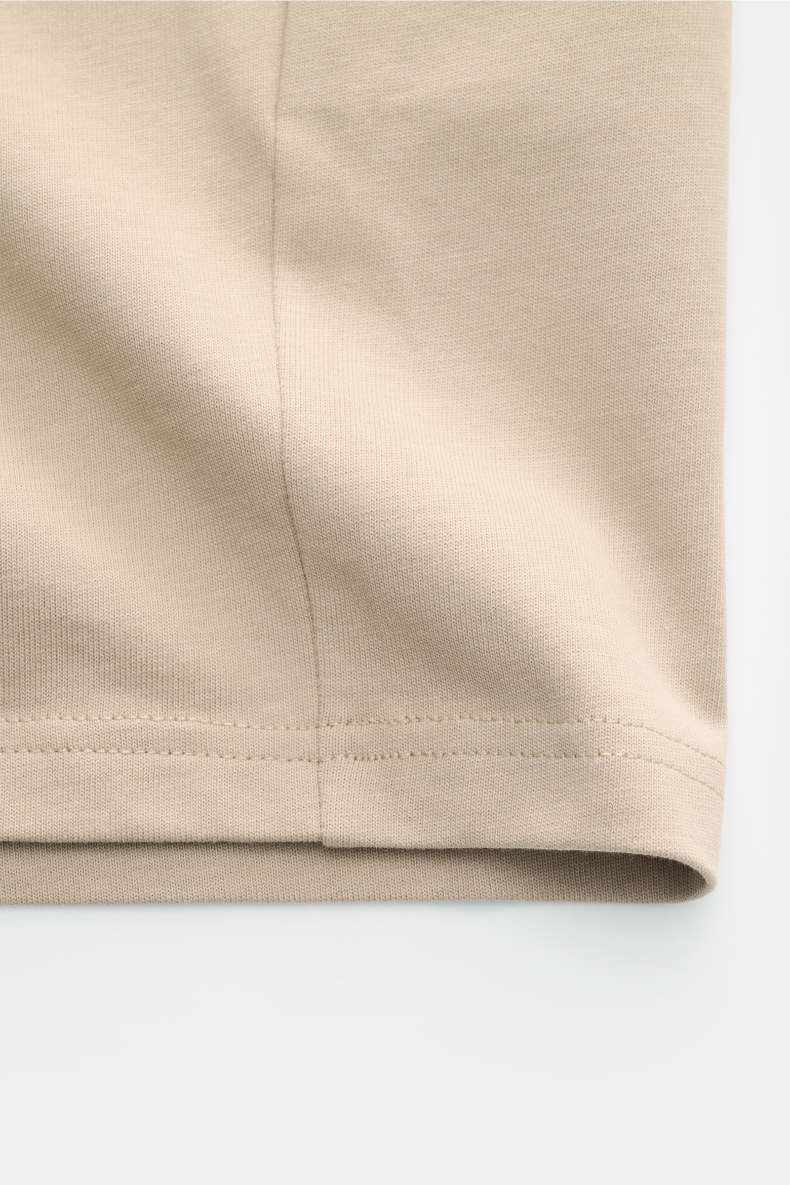 Nahaufnahme des Saums vom Ami Paris Rundhals-T-Shirt taupe aus Jersey-Baumwolle, abgesteppter Saum, weicher Griff, Oversized Fit.