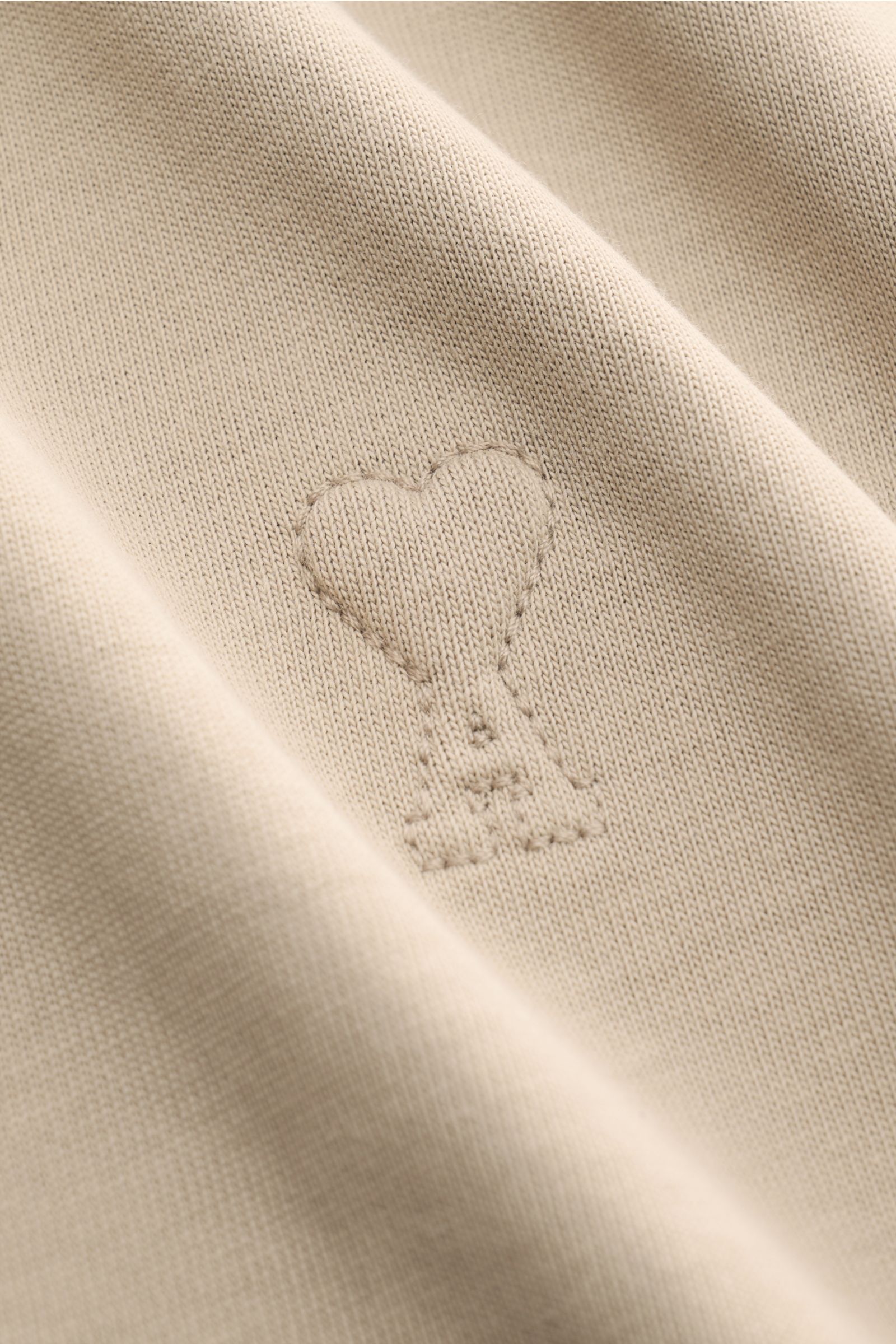 Nahaufnahme des Ami Paris Rundhals-T-Shirt taupe mit abgesteppem Herz-Logo aus schwerer Baumwolle, weicher Griff und Oversized Fit.