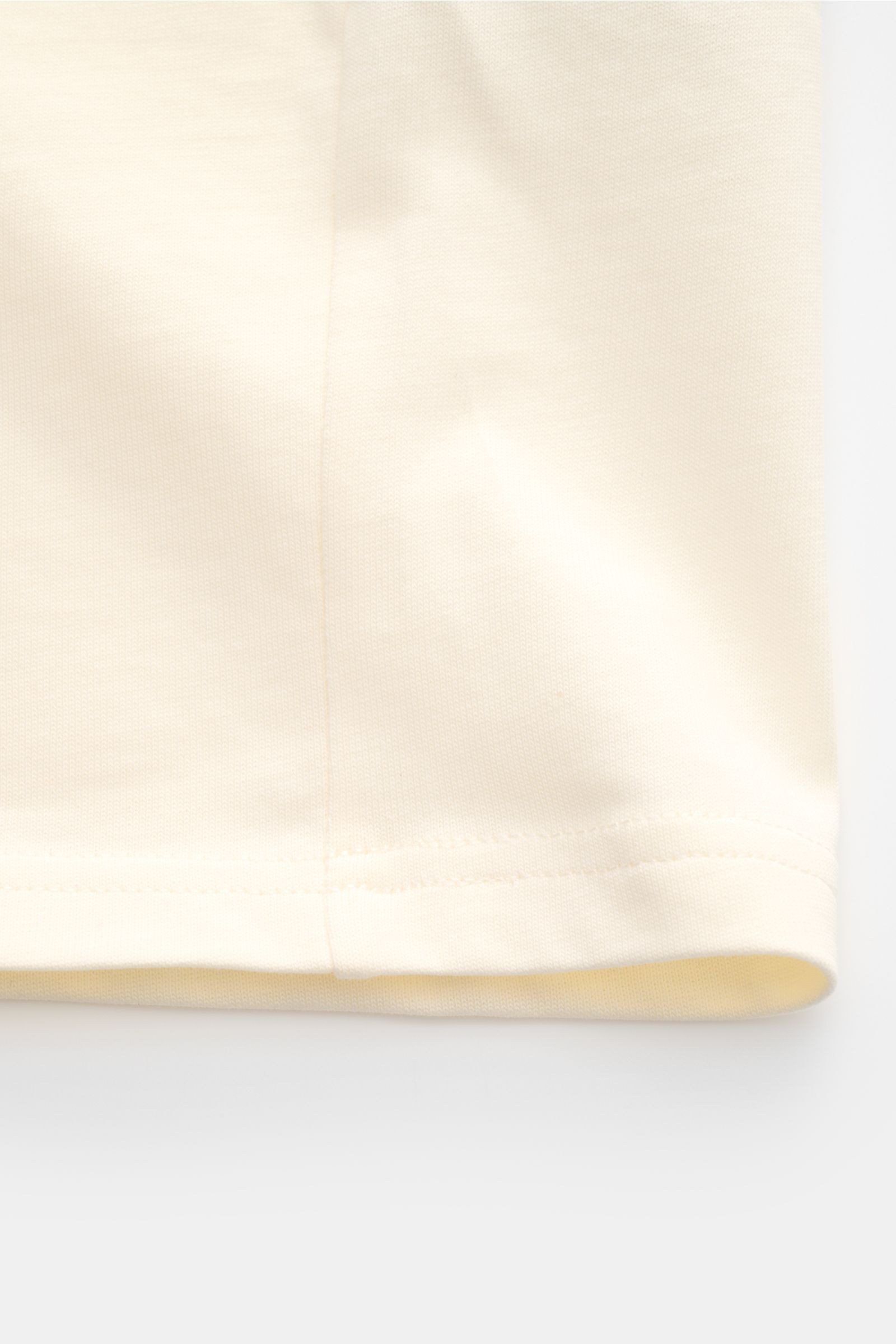 Ami Paris Rundhals-T-Shirt creme, Detailfoto vom Saum mit schwerem Jersey aus reiner Baumwolle, weicher Griff, Oversized Fit, abgesteppte Naht