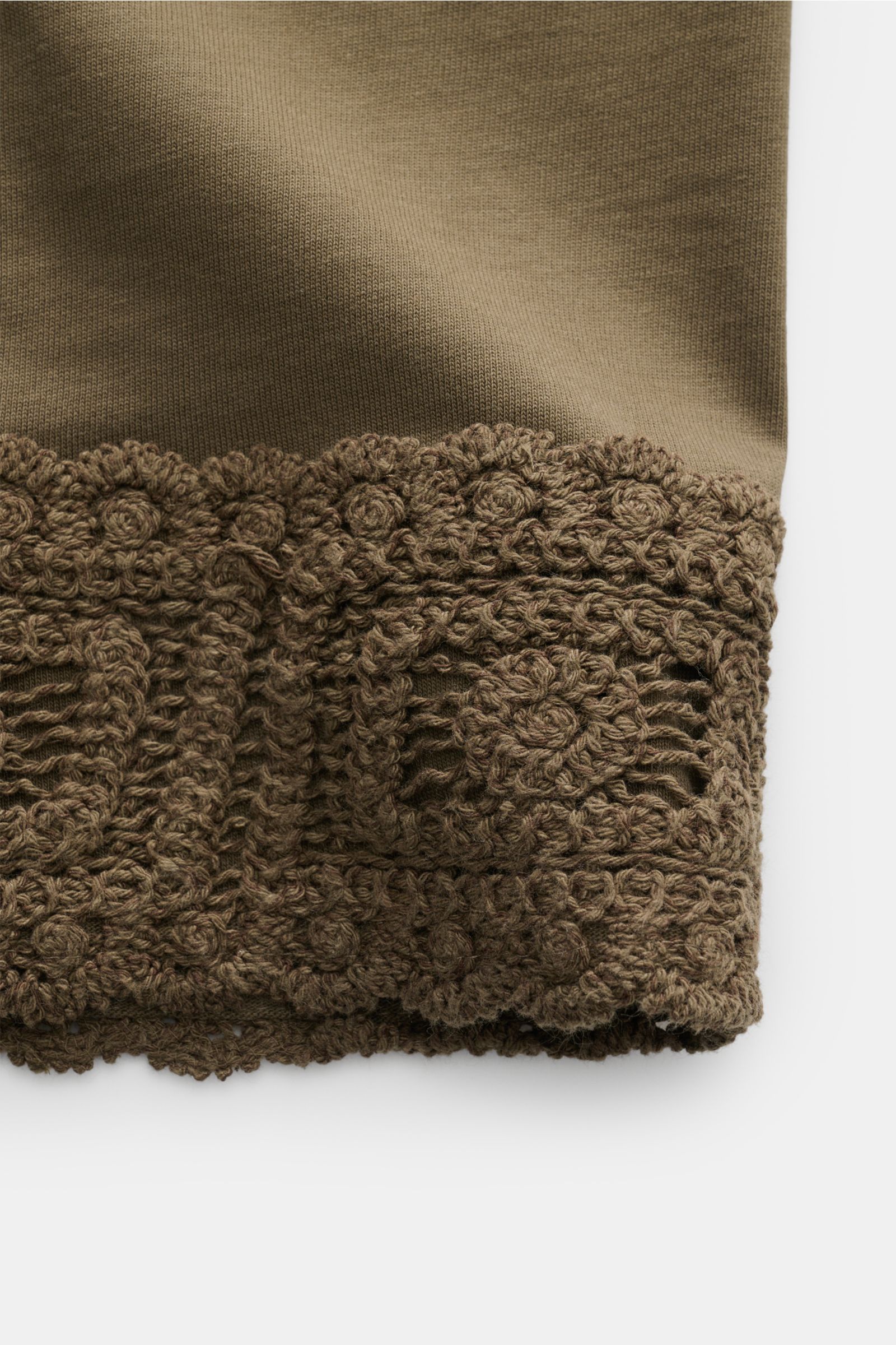 Close-up, top-down view of the crochet hem detail on the dark olive Ché T-Shirt 'Inigo.'

Description: Sommerliche Lässigkeit: Die Das 'Inigo' T-Shirt von CHÉ wird mit seinen Häkel-Details zum stilvollen Blickfang für entspannte Urlaubstage.

