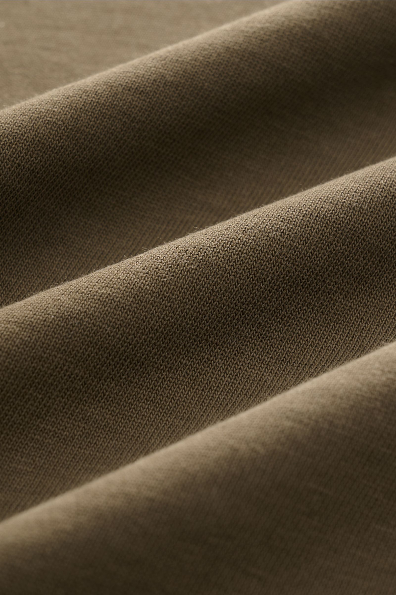 Close-up fabric detail of the Ché T-Shirt 'Inigo' dark olive, showing soft pure cotton texture from a side angle.

Description: Sommerliche Lässigkeit: Die Das 'Inigo' T-Shirt von CHÉ wird mit seinen Häkel-Details zum stilvollen Blickfang für entspannt