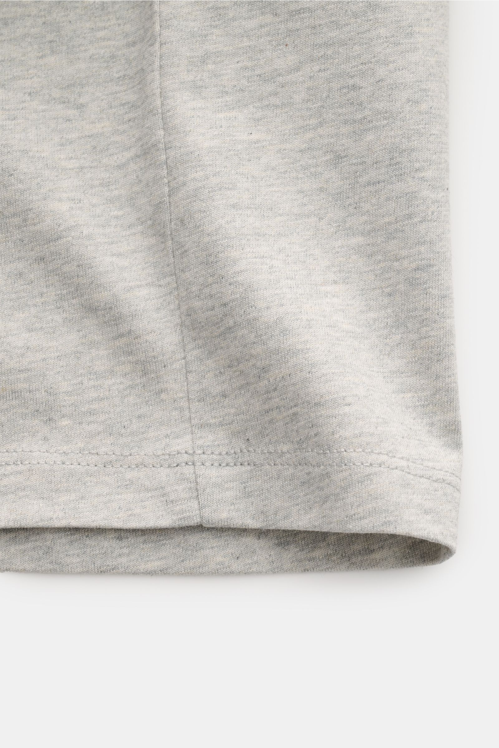 Close-up front view of the lower hem of the Ami Paris Rundhals-T-Shirt grau meliert, a classic slim fit grey melange cotton jersey T-shirt with soft texture.

Klassisches Jersey-Basic vom französischen Label AMI PARIS: Dieses T-Shirt mit Rundhalsaussch