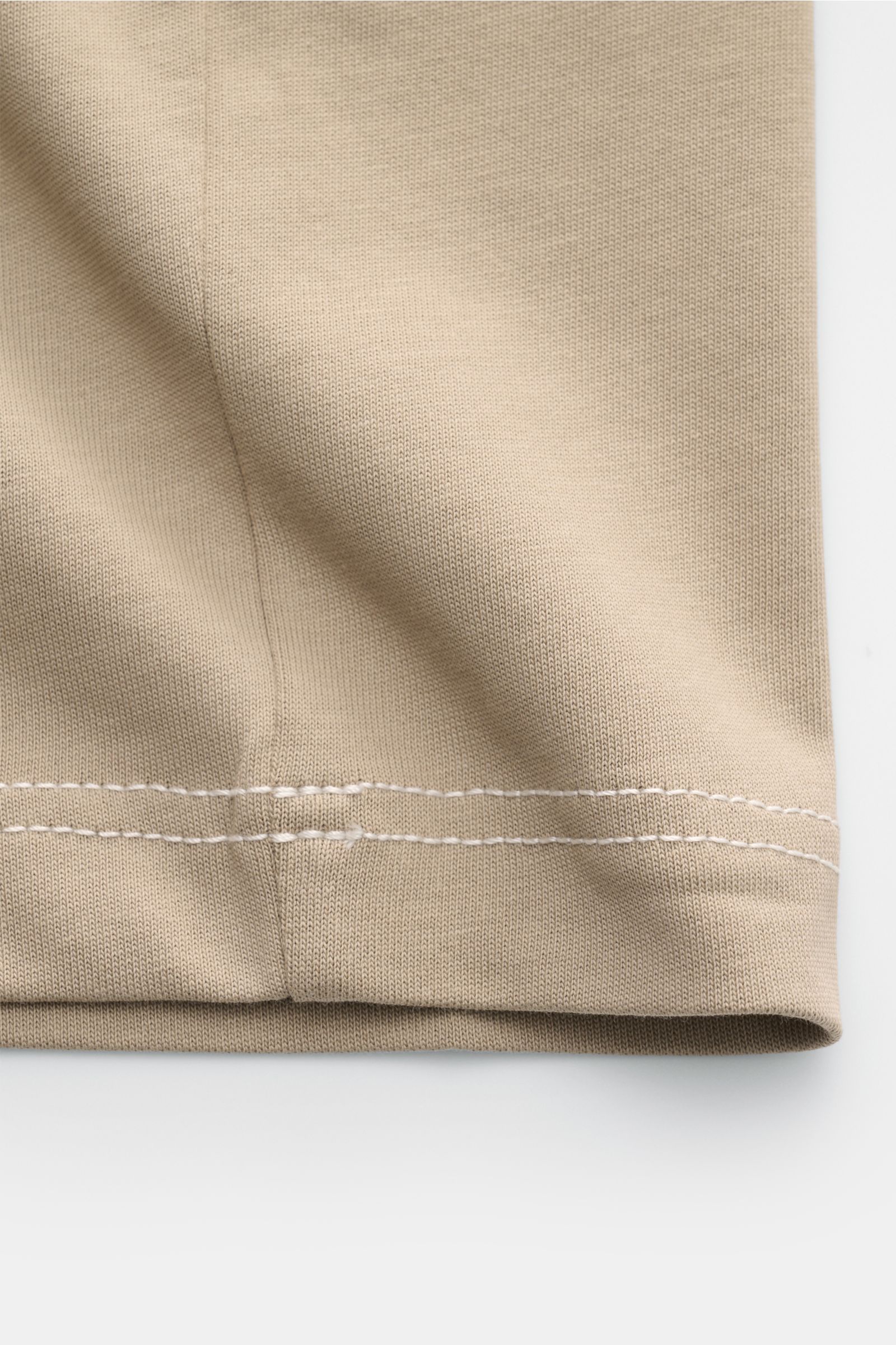 Close-up of the hem and stitching detail on the Ami Paris Rundhals-T-Shirt taupe, photographed from the side on a white background.

Mit diesem T-Shirt von AMI PARIS können Sie coole Streetstyles kombinieren - die abgesteppten Nähte und das typische He