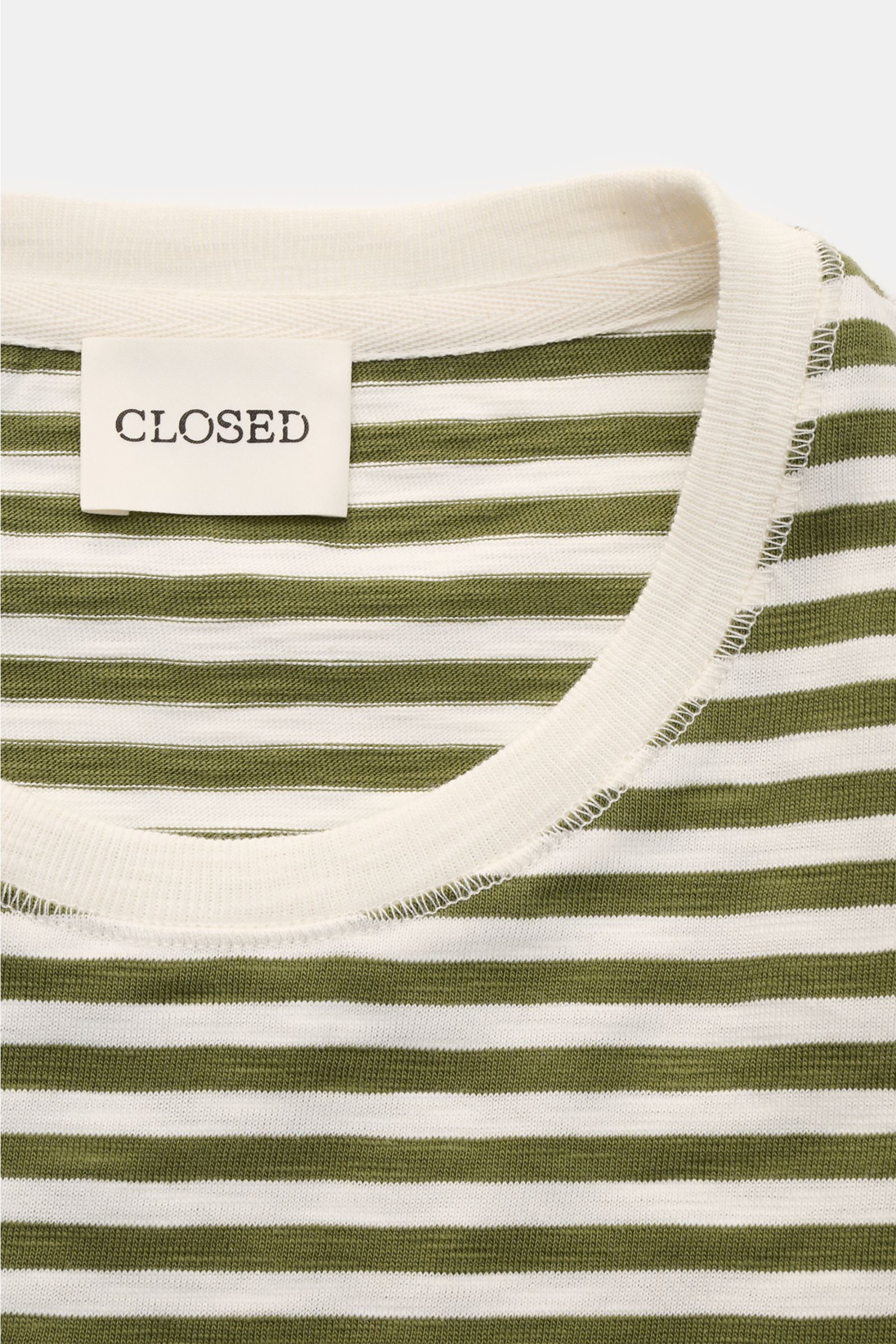 Close-up front view of the Closed Rundhals-T-Shirt oliv/offwhite gestreift showing the olive and off-white knitted stripe pattern, round neckline with soft ribbed trim, and the white label with 'CLOSED' text, made of pure organic cotton with a slim fit an