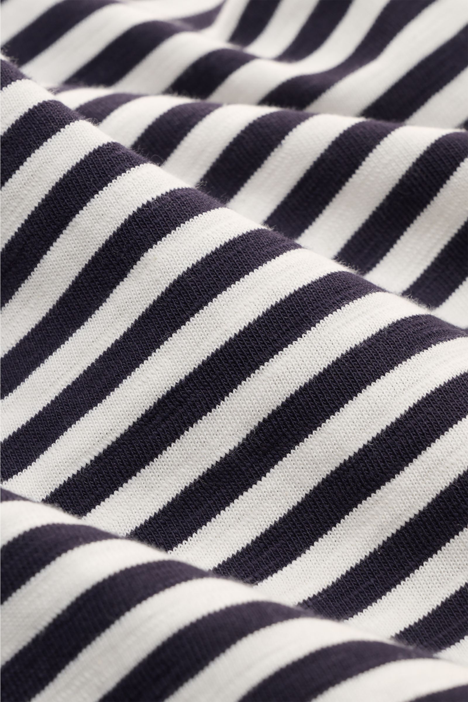 Closed Rundhals-T-Shirt dark navy/offwhite gestreift fabric close-up showing knitted stripe pattern and texture from an angled perspective.