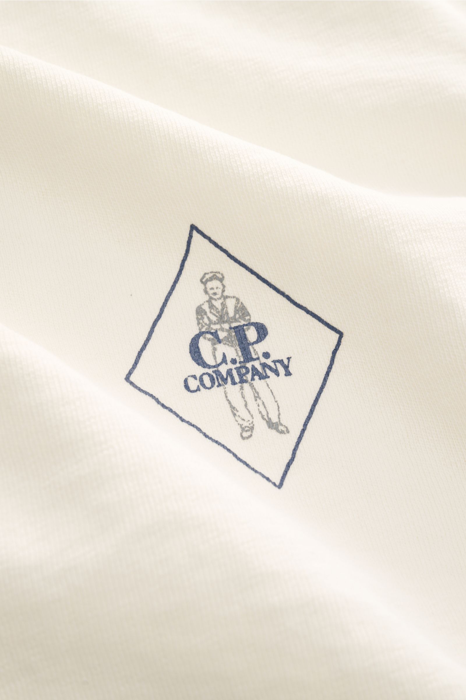 Alt tag (125 characters max): Close-up front view of C.P. Company Crew neck short sleeve sweatshirt cream with retro logo print on lightweight fabric.

Description: This lightweight short sleeve sweatshirt with small logo print on the front is a cool s