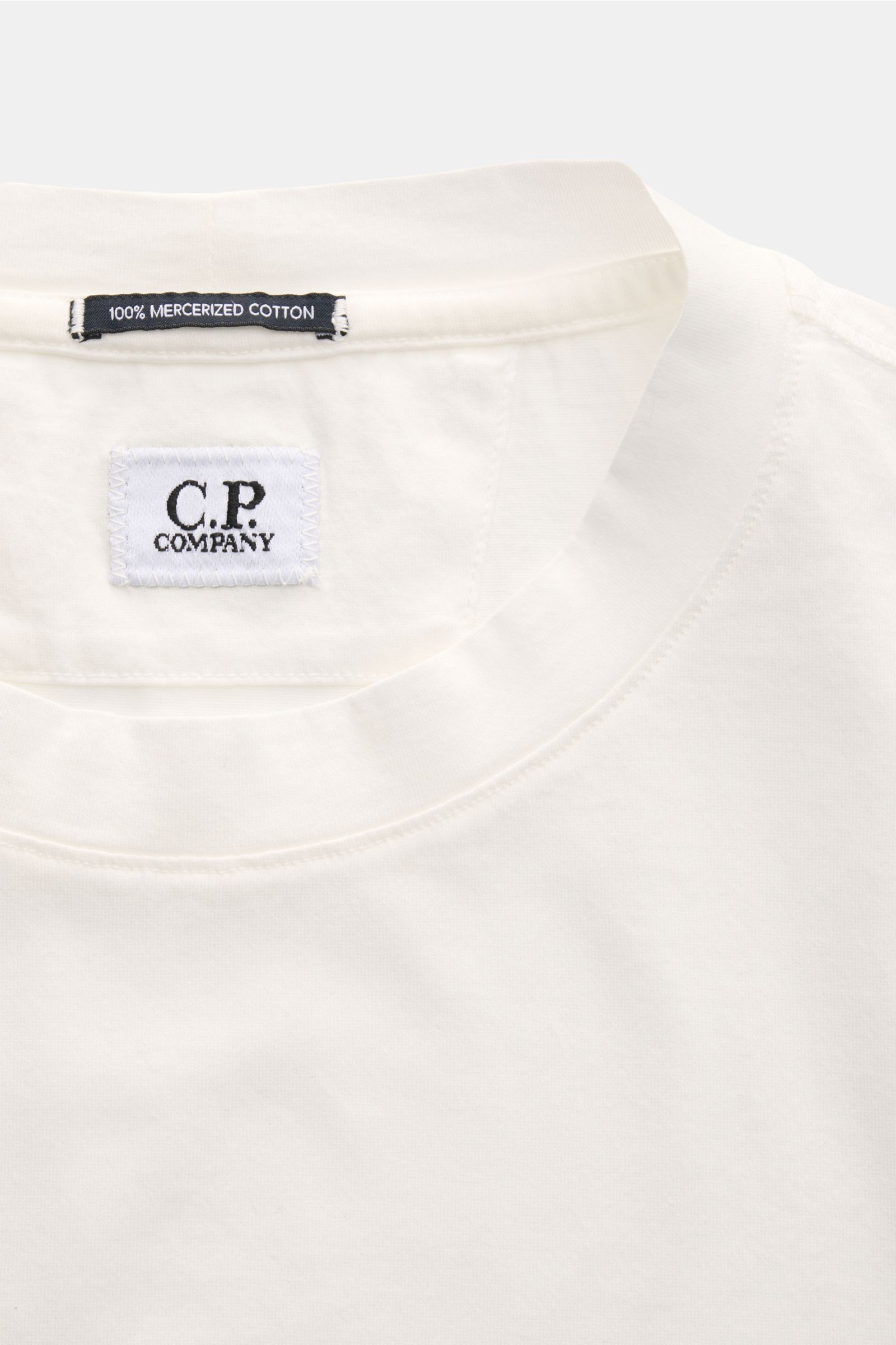 Close-up front view of C.P. Company Crew neck T-shirt off-white showing crew neck and brand labels inside collar.

C.P. COMPANY gives this classic T-shirt its unmistakable signature touch with a subtle logo print on the chest. Made of mercerised cotton