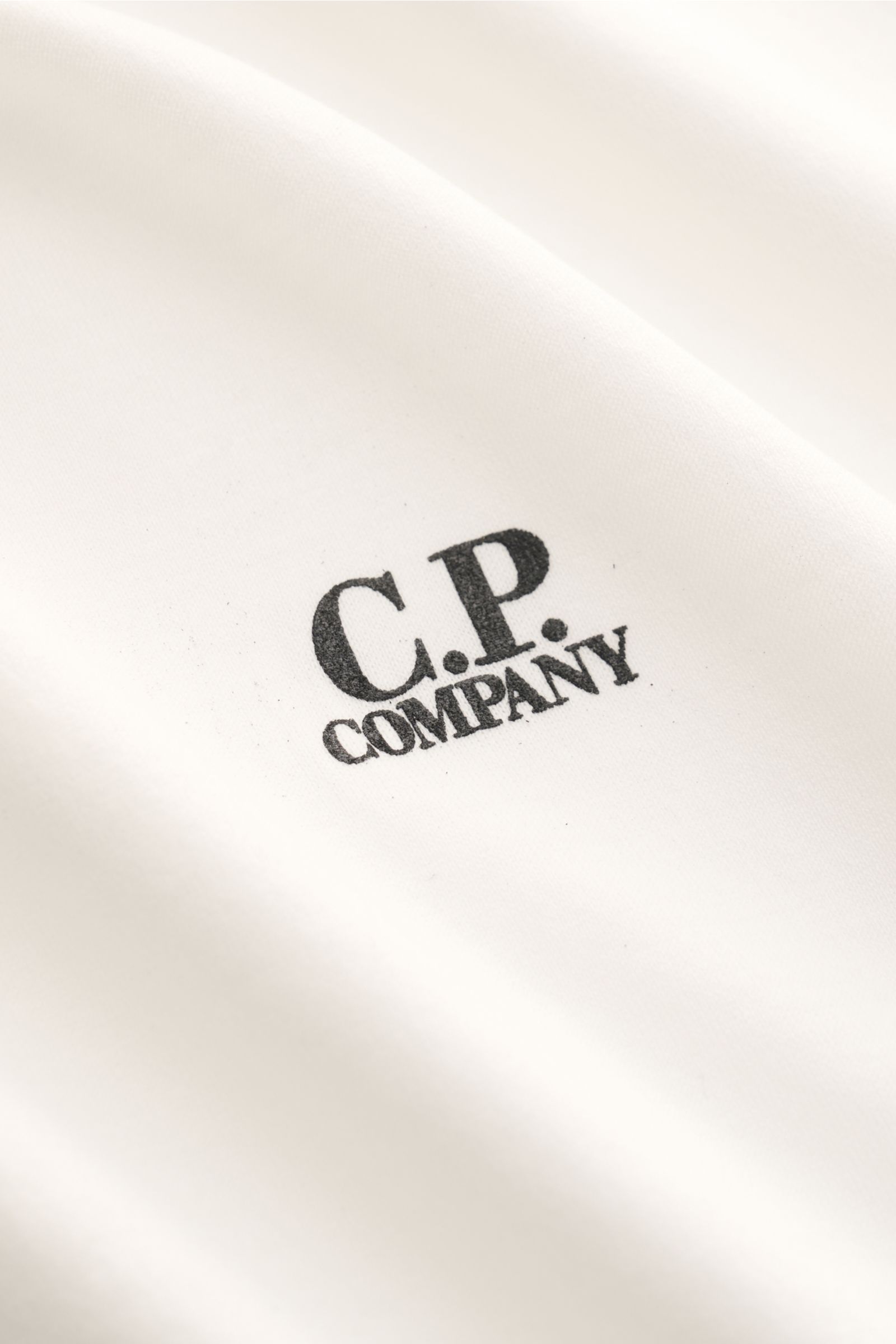Close-up front view of the C.P. Company Crew neck T-shirt off-white showing the subtle logo print on soft mercerised cotton fabric.

C.P. COMPANY gives this classic T-shirt its unmistakable signature touch with a subtle logo print on the chest. Made of