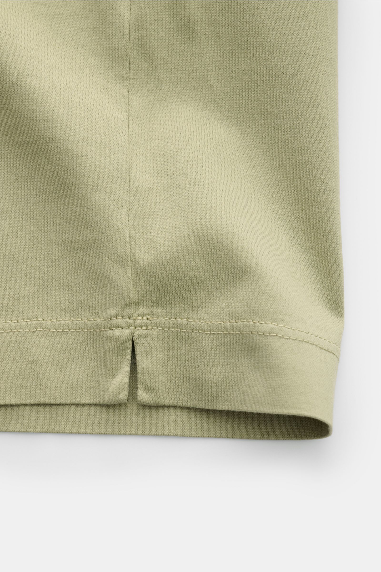 Close-up of the hem and side slit of the C.P. Company Crew neck T-shirt olive, showing soft mercerised cotton jersey fabric from a front-side perspective.

C.P. COMPANY gives this classic T-shirt its unmistakable signature touch with a subtle logo prin