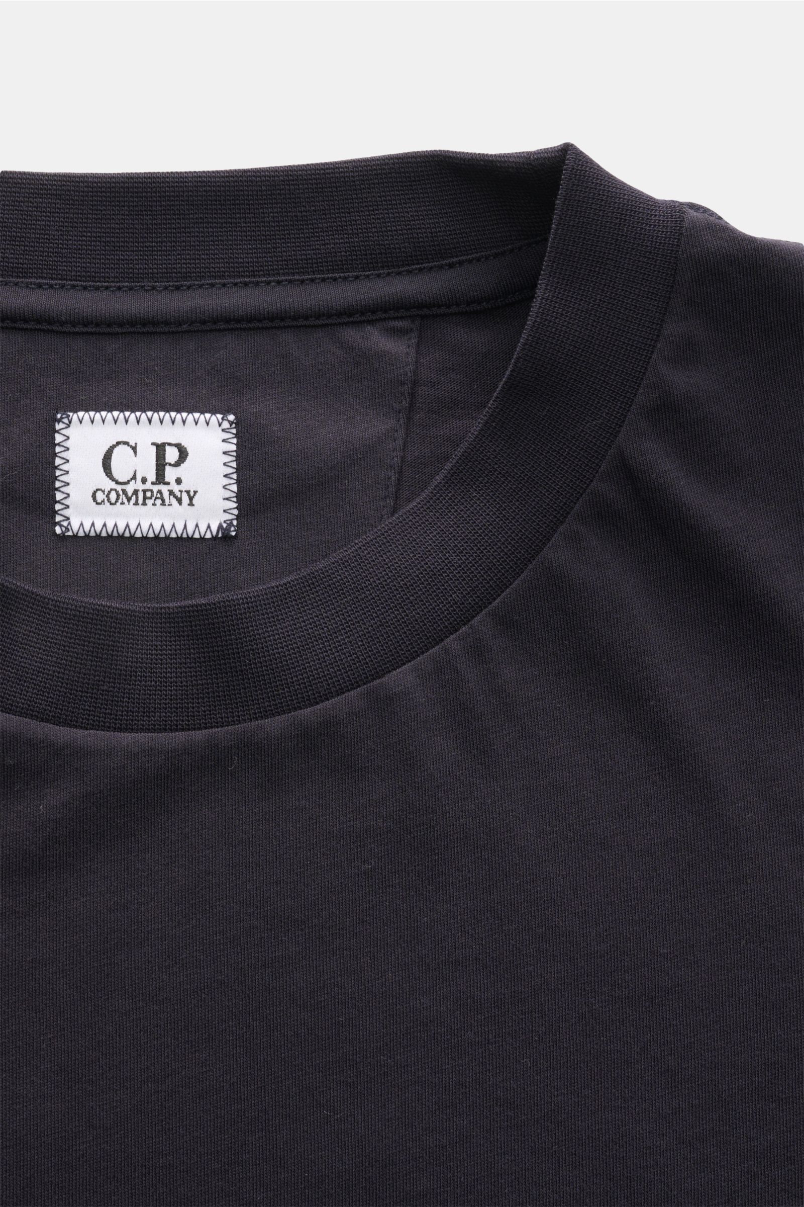 Nahaufnahme des Rundhalsausschnitts vom C.P. Company T-Shirt dark navy, reine Baumwolle, weicher Griff, Slim Fit, Logo-Label innen.