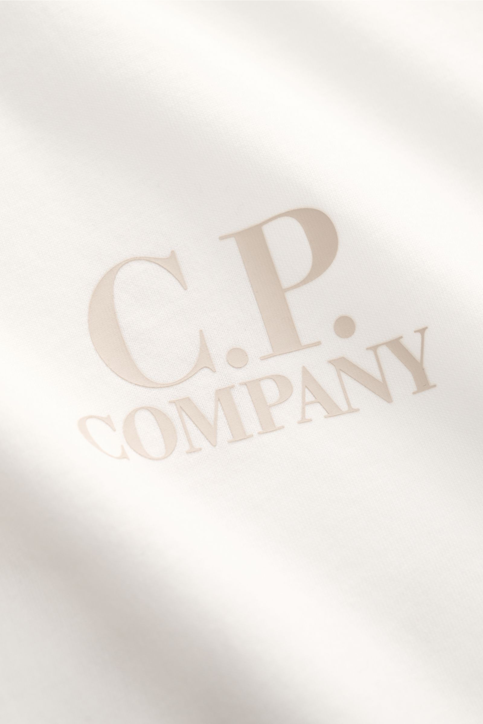 C.P. Company T-Shirt offwhite in Nahaufnahme von vorne mit Logo-Print auf Brust, Slim Fit, Rundhals, reine Baumwolle, weicher Griff.