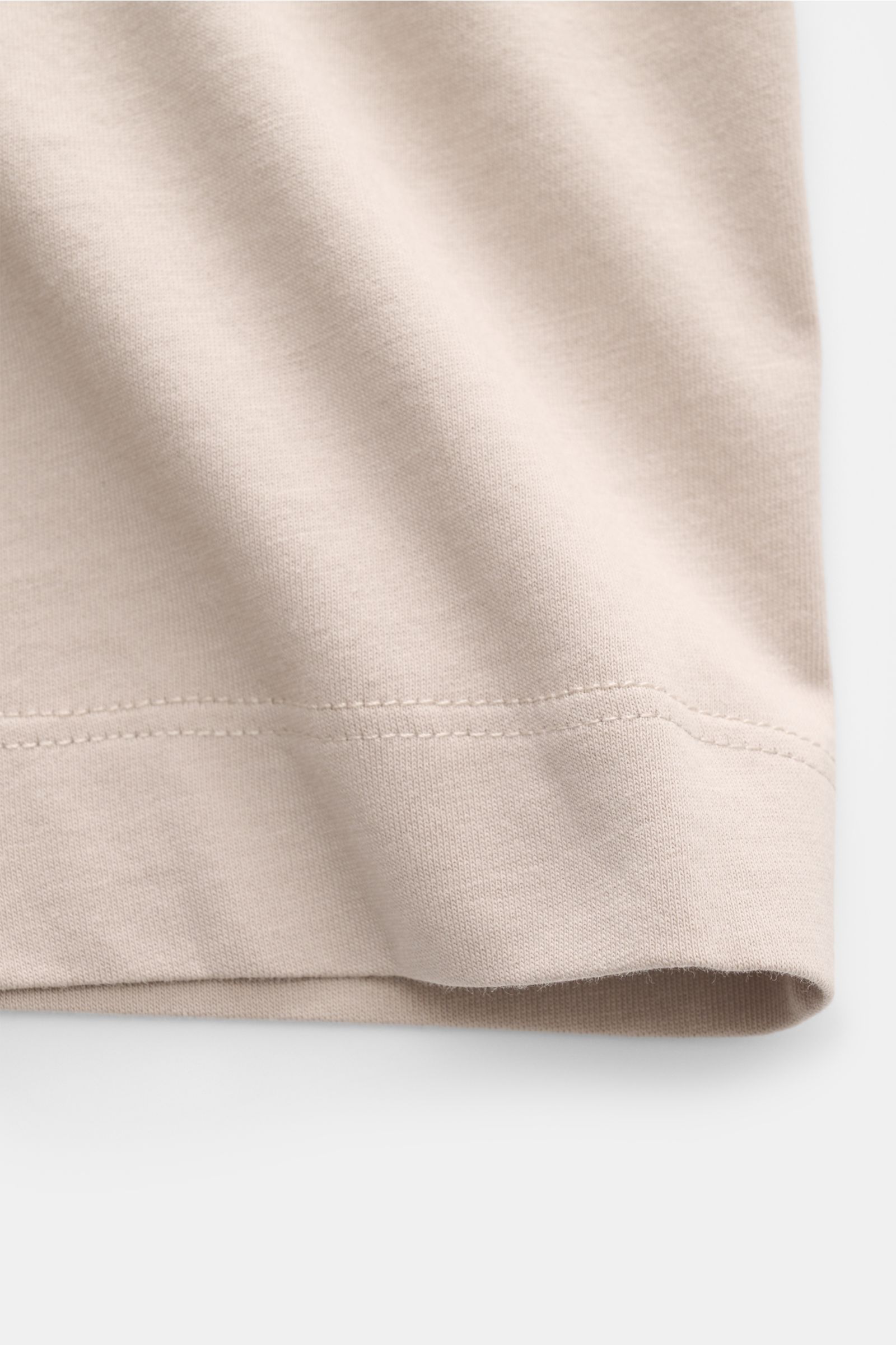 Nahaufnahme des beigen C.P. Company T-Shirts aus reiner Baumwolle mit weichem Griff, Slim Fit, Rundhalsausschnitt und sichtbarer Saumnaht.