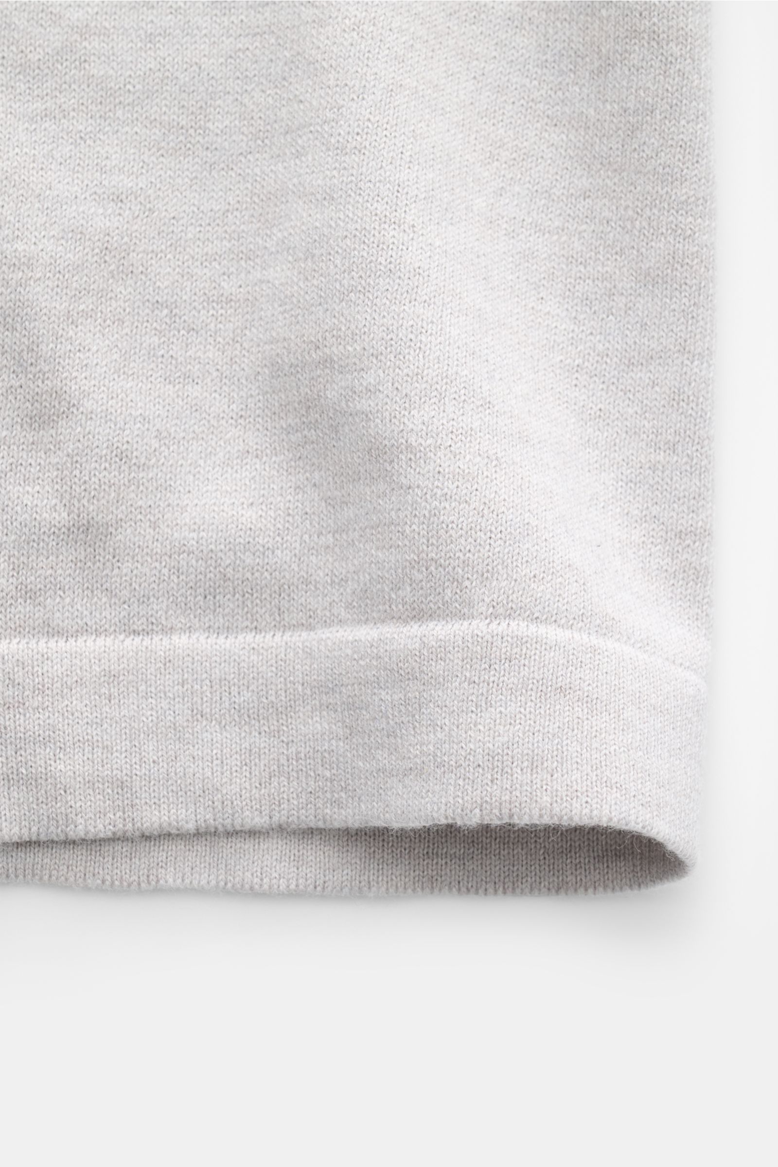 Soft Goat Kurzarmpullover hellgrau close-up of fine knit cotton-cashmere mix fabric and hem, photographed from front side. Modernes Essential: Gefertigt aus einem edlen Baumwoll-Cashmere-Mix, wird der Kurzarmpullover von SOFT GOAT zum stilvollen Basic für