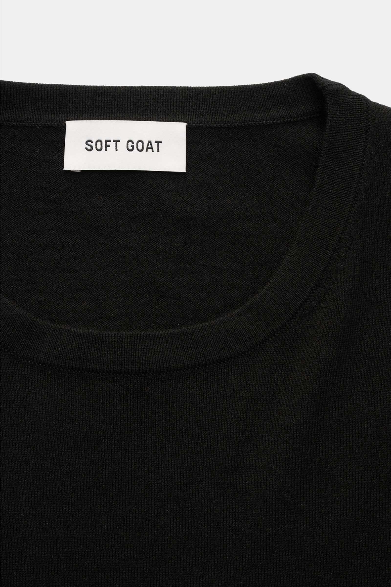 Close-up front view of Soft Goat Short sleeve jumper black showing crew neck and fine knit texture with label.

Description:  
A modern essential: Made from a luxurious blend of cashmere and cotton, this short sleeve jumper by SOFT GOAT is the perfect 