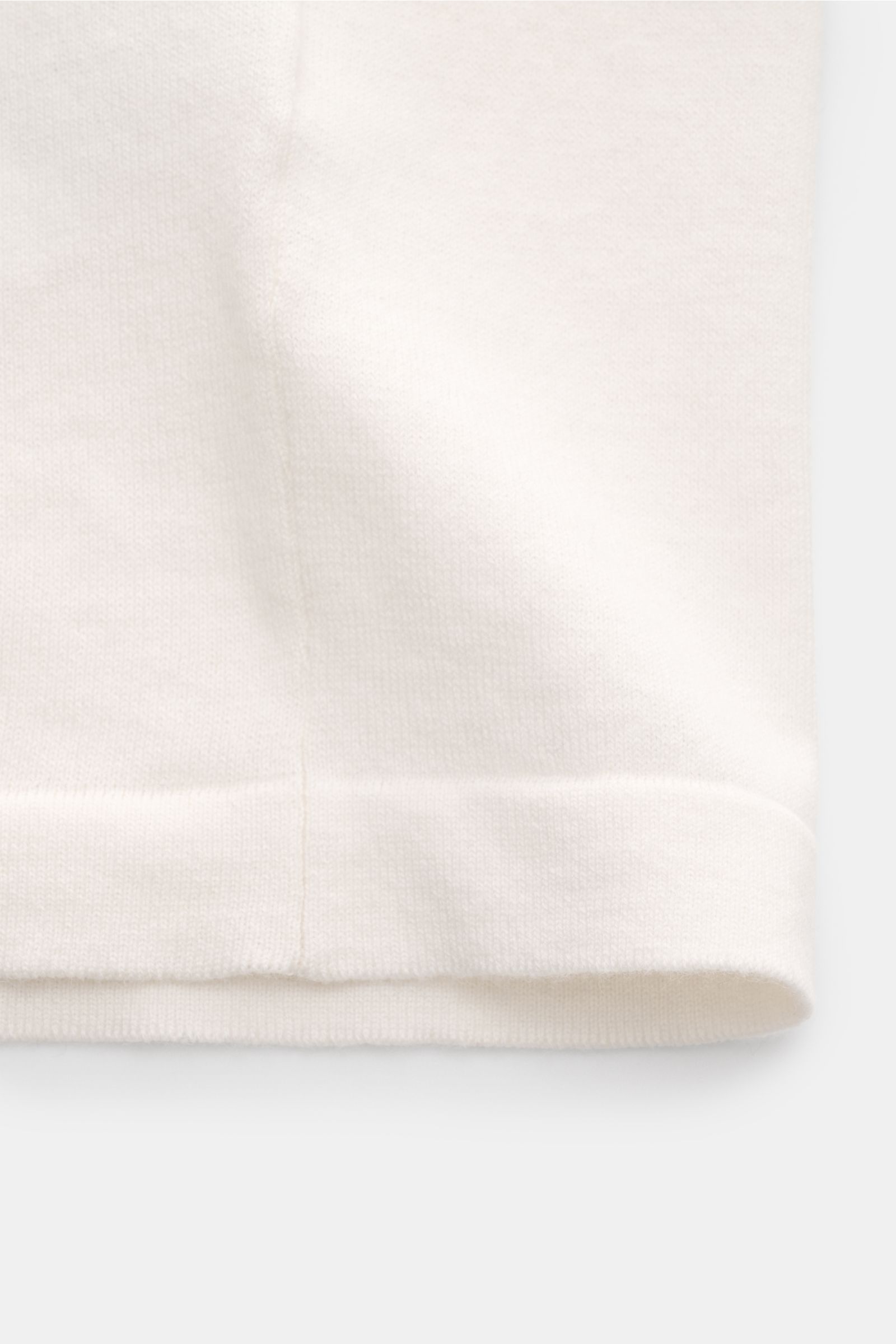 Soft Goat Kurzarmpullover creme aus Baumwoll-Cashmere-Mix, feines Strickbild, weicher Griff, Oversized Fit, Nahaufnahme der Saumkante von unten.