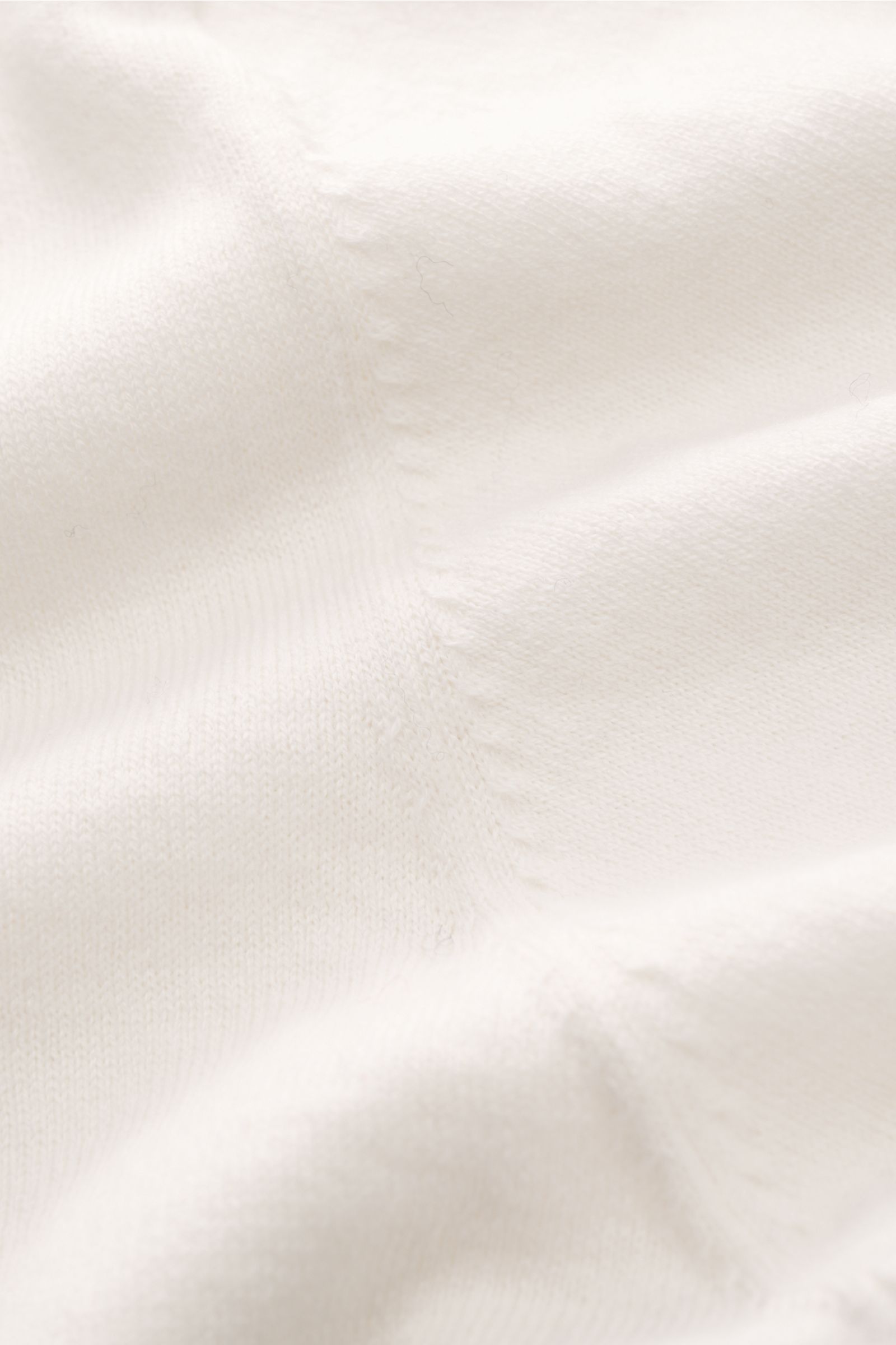 Soft Goat Kurzarmpullover creme in Nahaufnahme, feines Strickbild, weicher Baumwoll-Cashmere-Mix, Oversized Fit, Rundhalsausschnitt sichtbar.