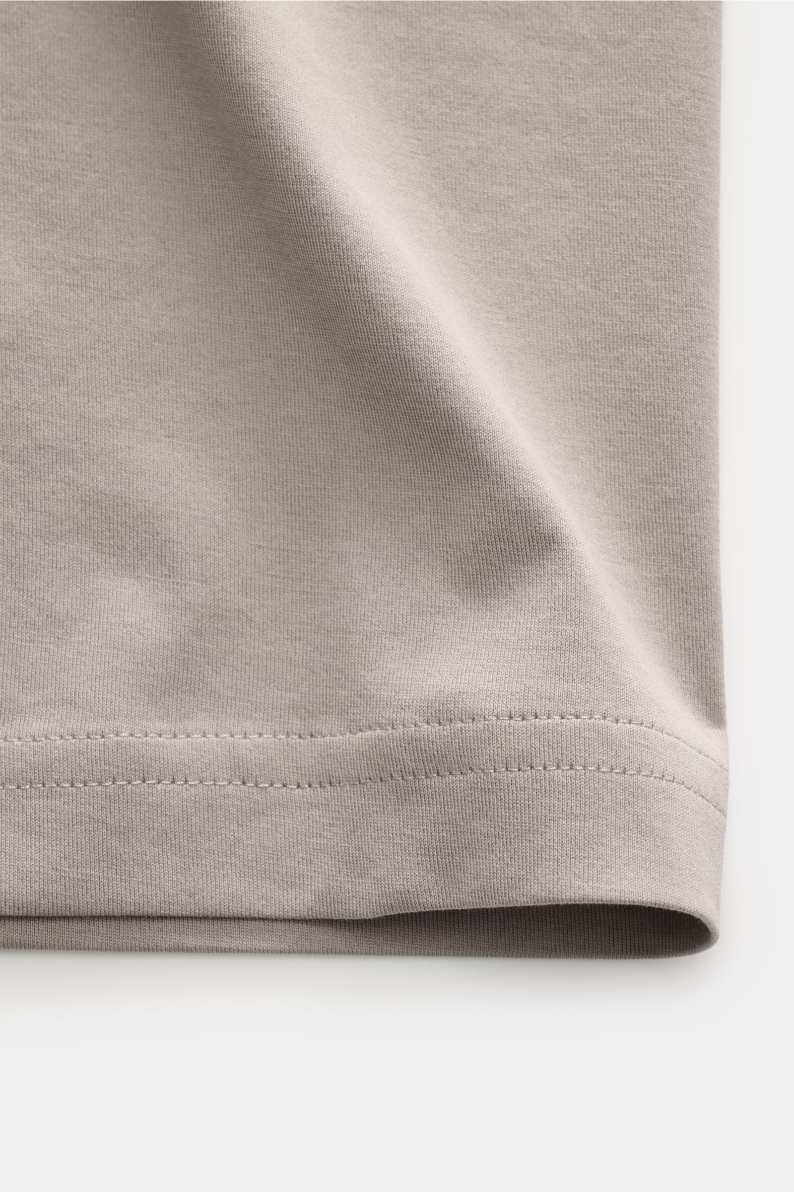 Nahaufnahme des taupefarbenen Saums vom Stefan Brandt Rundhals-T-Shirt 'Enno' aus weichem Urpima Sea Island Baumwoll-Jersey.