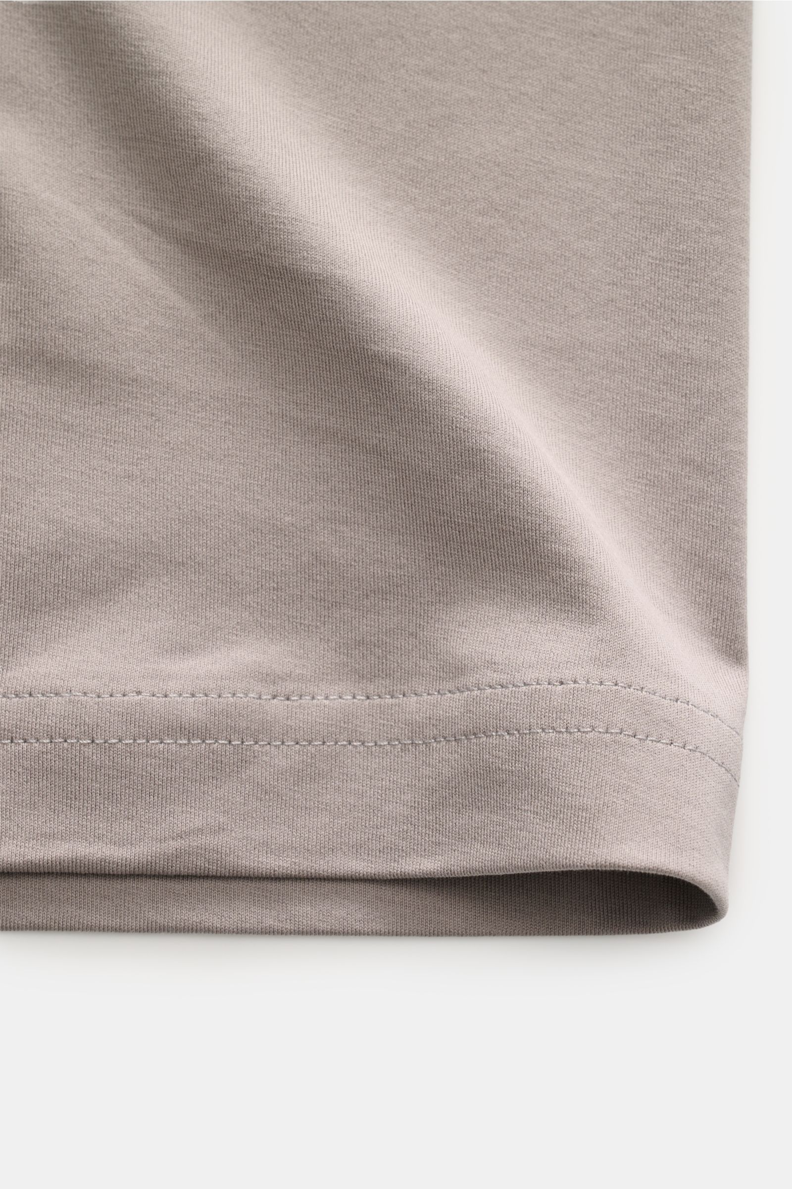 Nahaufnahme des Saums vom Stefan Brandt V-Neck T-Shirt 'Artur' taupe aus biologischer Pima-Baumwolle, Slim Fit, feine Jersey-Qualität, sehr weicher, seidiger Griff, fotografiert von unten.