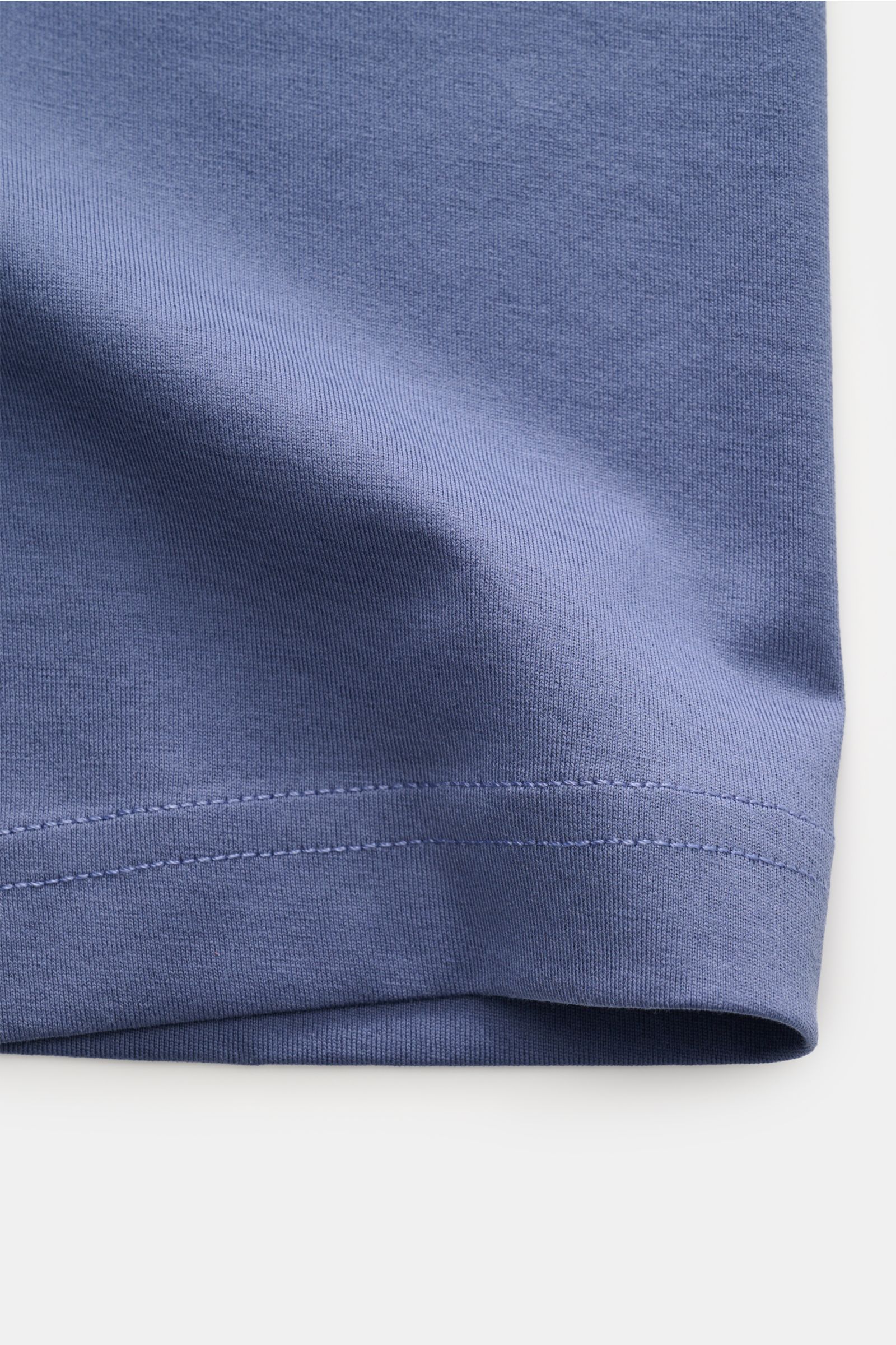 Nahaufnahme des Saums vom Stefan Brandt V-Neck T-Shirt 'Artur' rauchblau aus weicher, biologischer Pima-Baumwolle in feiner Jersey-Qualität, Slim Fit.