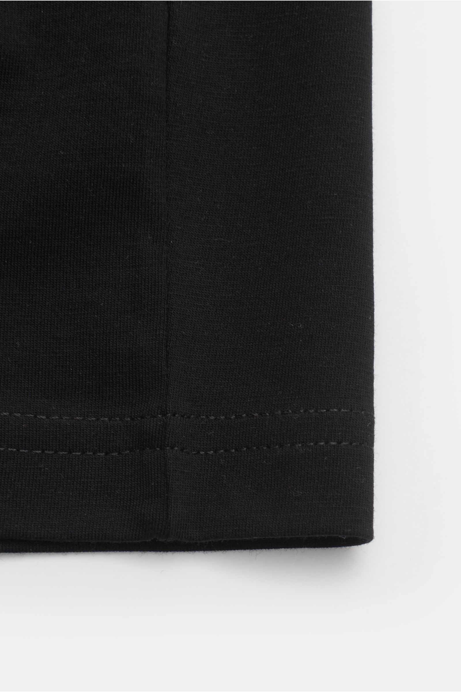Black close-up of the hem seam of the Stefan Brandt V-Neck T-Shirt 'Adam' schwarz, photographed from below. Luxuriöses Essential: Das V-Neck T-Shirt von STEFAN BRANDT aus edler 'Urpima Sea Island' Baumwolle besticht durch außergewöhnliche Weichheit und ze