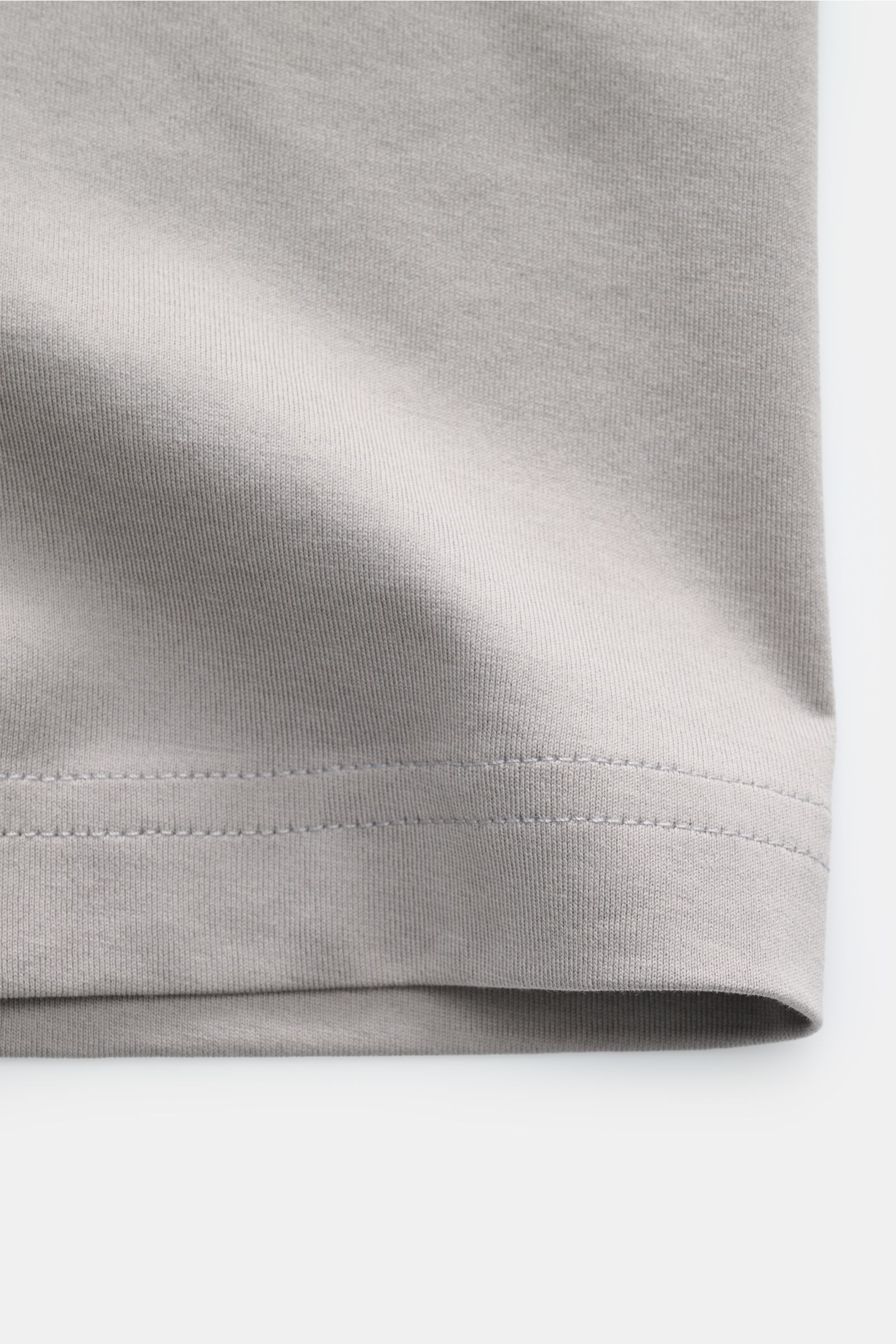 Close-up view of the hem of the Stefan Brandt V-Neck T-Shirt 'Adam' taupe, showcasing fine stitching and soft taupe Urpima Sea Island cotton fabric. Luxuriöses Essential: Das V-Neck T-Shirt von STEFAN BRANDT aus edler 'Urpima Sea Island' Baumwolle best
