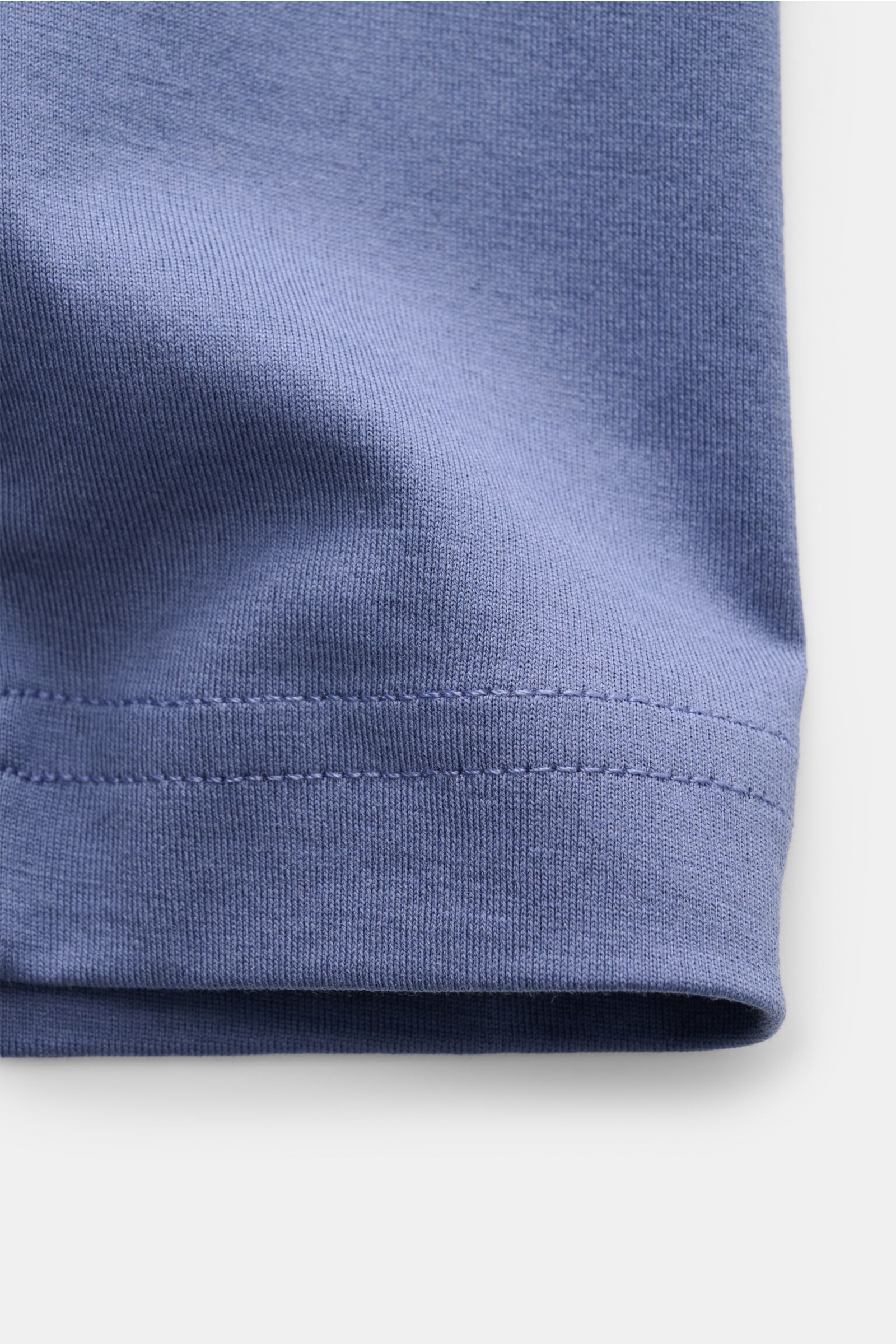 Nahaufnahme des Saums vom Stefan Brandt V-Neck T-Shirt 'Adam' graublau aus reiner Urpima Sea Island Baumwolle, sehr weicher Griff, Slim Fit, V-Ausschnitt, fotografiert von der Seite.