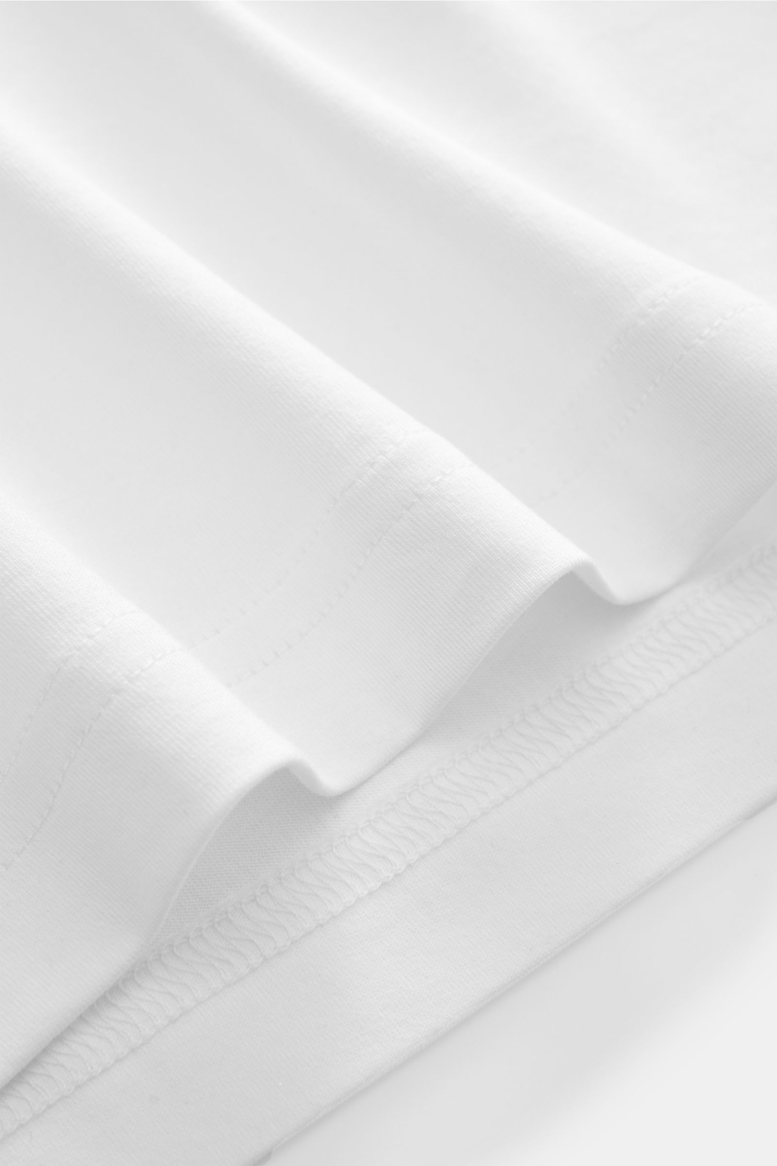 Close-up front view of Stefan Brandt V-Neck T-Shirt 'Adam' weiß showing smooth white fabric and stitching details. Luxuriöses Essential: Das V-Neck T-Shirt von STEFAN BRANDT aus edler 'Urpima Sea Island' Baumwolle besticht durch außergewöhnliche Weichheit