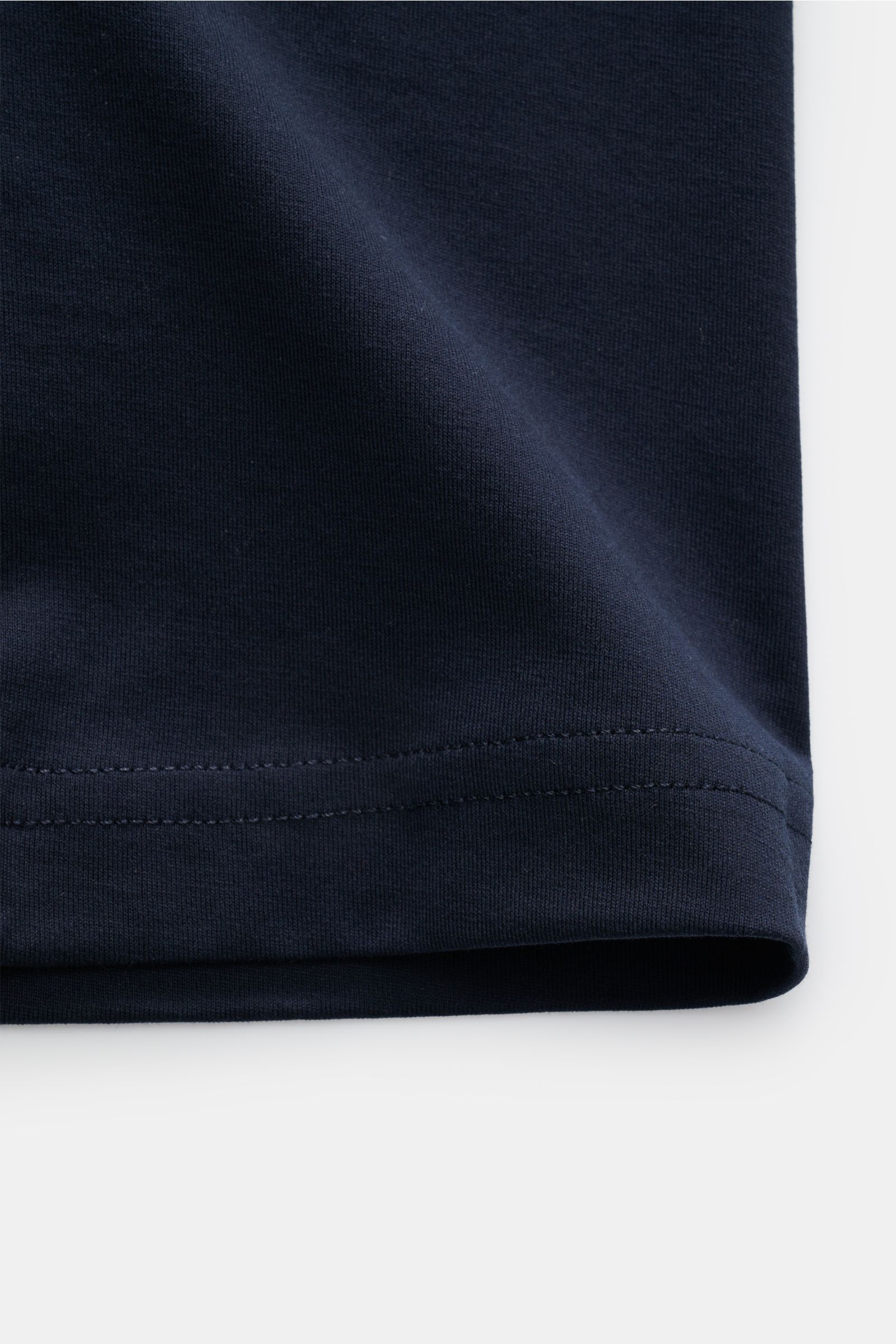 Close-up side view of the Stefan Brandt Rundhals-T-Shirt 'Eli' navy hem, showcasing fine jersey fabric and stitching detail, made from pure 'Urpima Sea Island' cotton. Jersey in seiner feinsten Qualität: Mit seinem Expertenwissen über Materialien schafft 