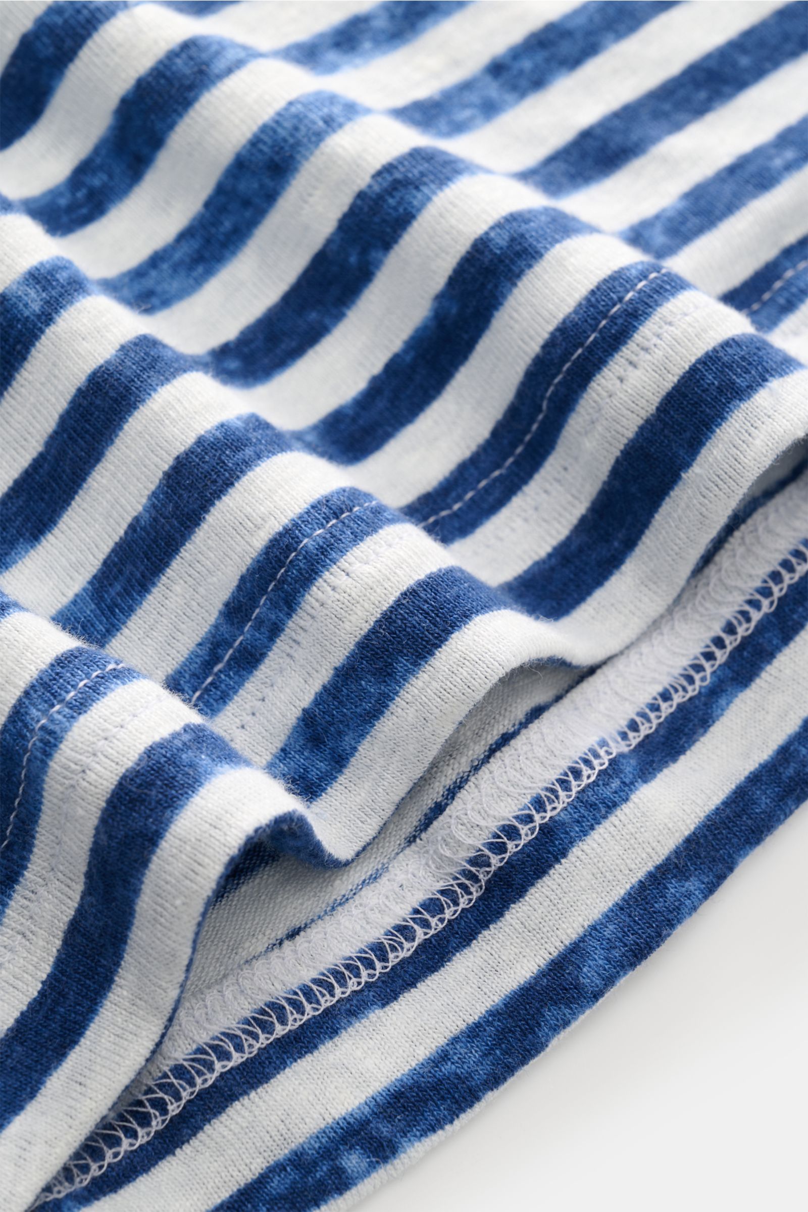 Nahaufnahme des blau/creme gestreiften Stefan Brandt Leinen Rundhals-T-Shirts, Blick auf Jersey mit elastischer, weicher Struktur.