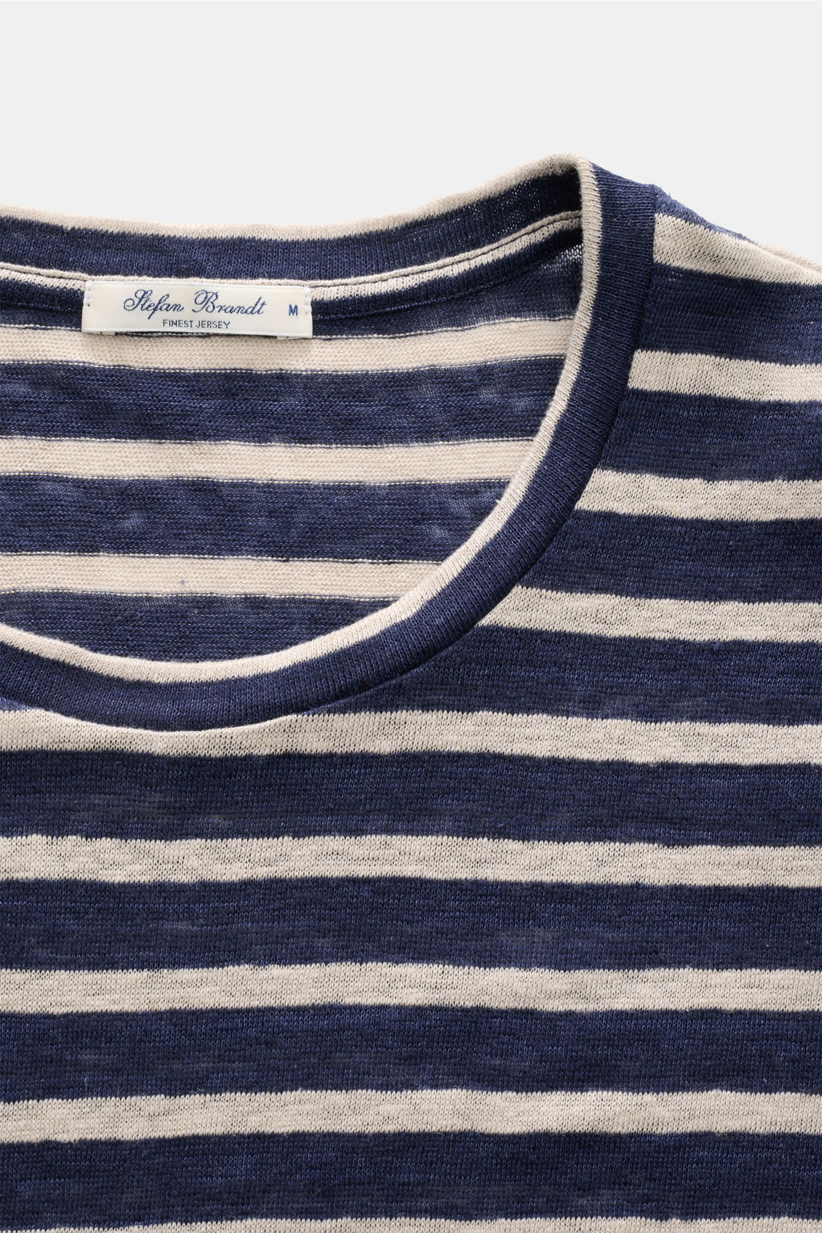 Close-up front view of Stefan Brandt Leinen Rundhals-T-Shirt 'Enno' navy/sand gestreift, highlighting the round neckline and label. Sommerliche Leichtigkeit in ihrer edelsten Form: Das Rundhals-T-Shirt 'Enno' von STEFAN BRANDT aus reinem belgischen Leinen