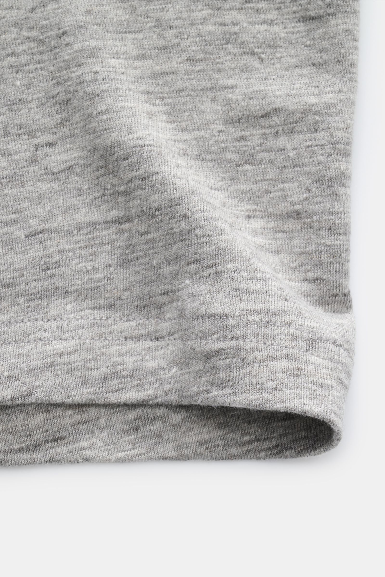 Close-up view of the hem and fabric texture of the Stefan Brandt Leinen Rundhals-T-Shirt 'Enno' grau meliert, showing the soft, lightweight, slightly elastic pure Belgian linen with its typical material structure, slim fit, and round neckline. Sommerliche