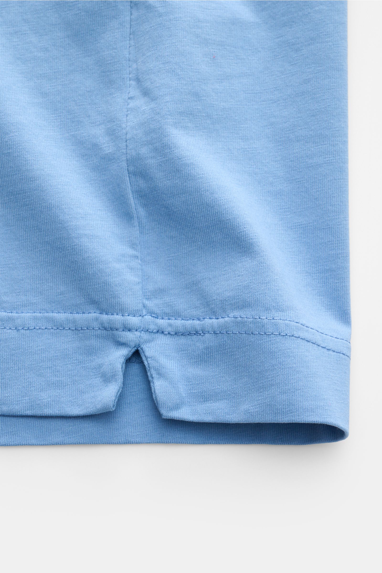 Nahaufnahme des unteren Saumbereichs mit kurzen Saumschlitzen des B.F. Knitwear Rundhals-T-Shirt rauchblau aus reiner Baumwolle, Slim Fit.