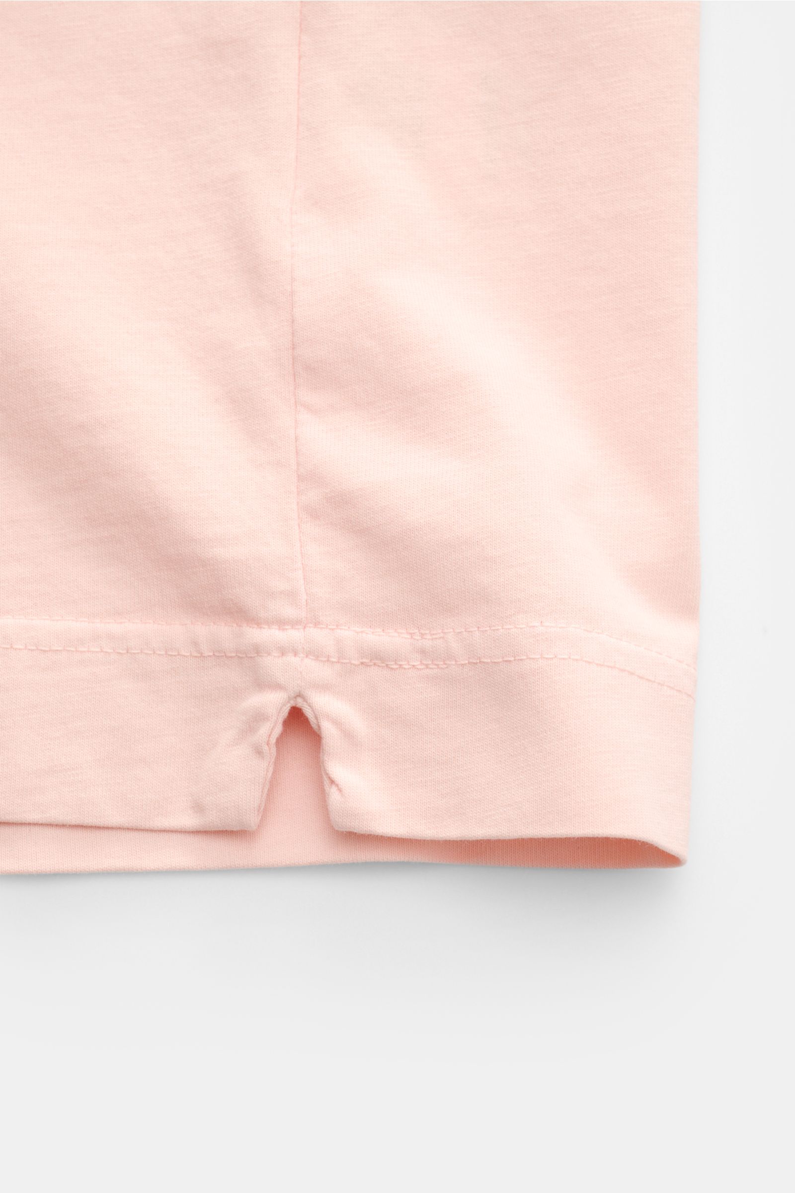Close-up view of the short hem vents on the B.F. Knitwear Crew neck T-shirt rose, made of pure cotton with a soft feel and slim fit. A high-quality basic for the spring and summer season, photographed from the bottom hem.