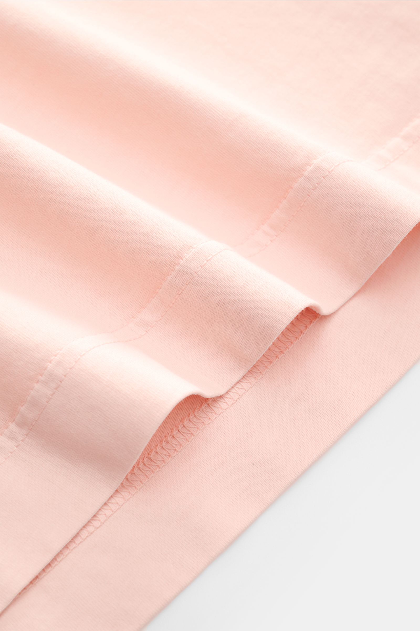 Close-up image of the hem with short vents of the B.F. Knitwear Crew neck T-shirt rose, showing pure cotton fabric and precise stitching from a side perspective. A high-quality basic for the spring and summer season: This T-shirt by B.F. KNITWEAR is ma