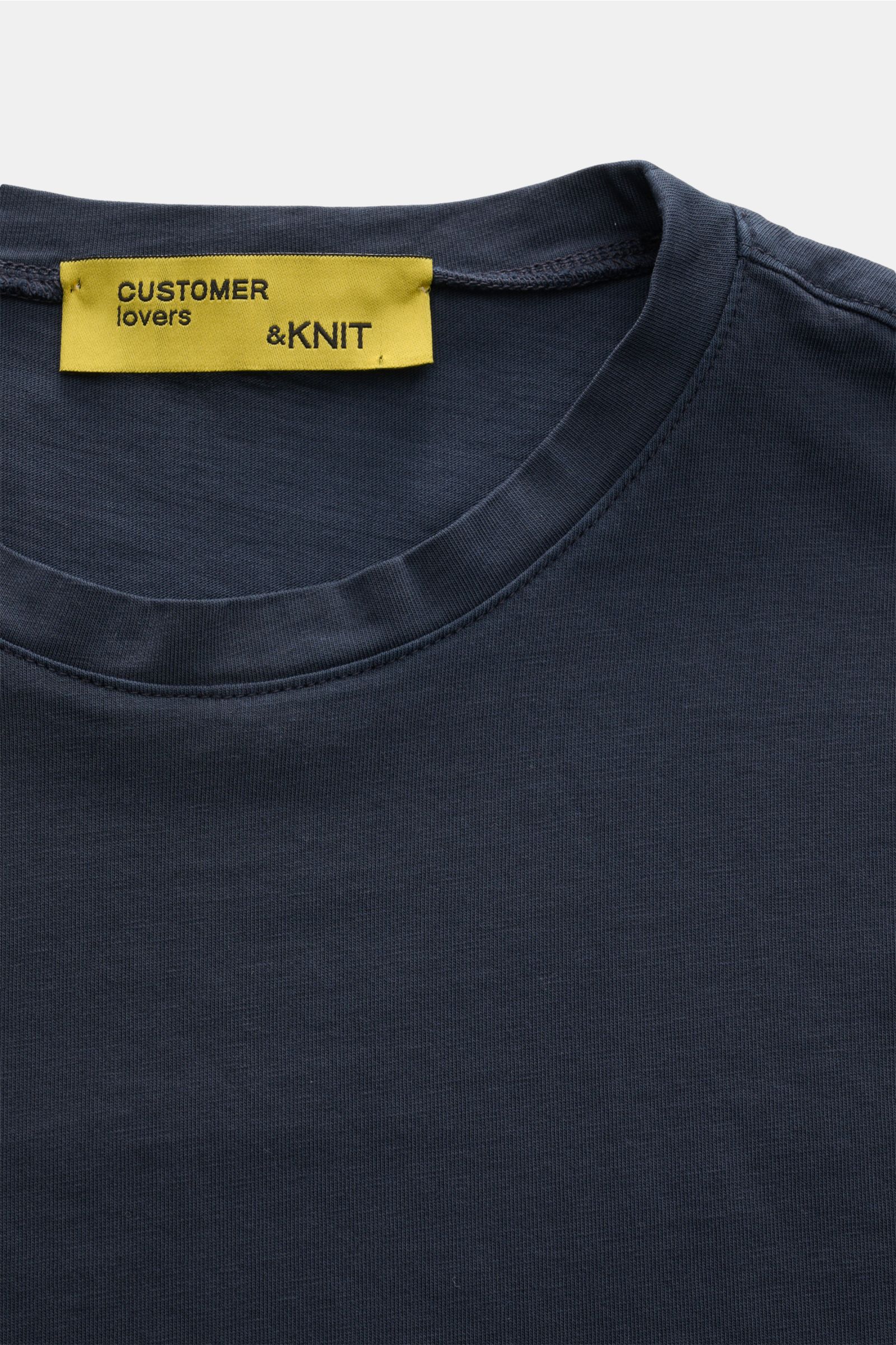 Close-up front view of B.F. Knitwear Crew neck T-shirt navy showing crew neck and yellow label with 'CUSTOMER lovers & KNIT.' 

A high-quality basic for the spring and summer season: This T-shirt by B.F. KNITWEAR is made of pure cotton fabric in a prec