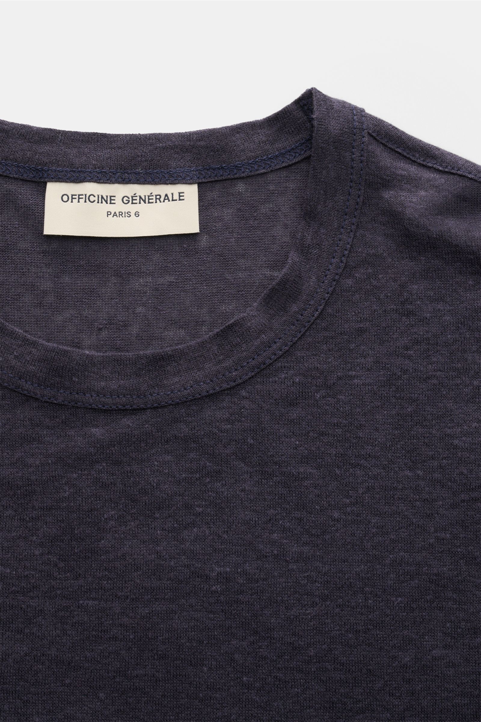 Close-up top view of Officine Générale Leinen Rundhals-T-Shirt navy showing the round neckline and label on soft, lightweight pure linen jersey.

Description: Die leichte Qualität aus reinem Leinen macht dieses Rundhals-T-Shirt von OFFICINE GÉNÉRALE zu