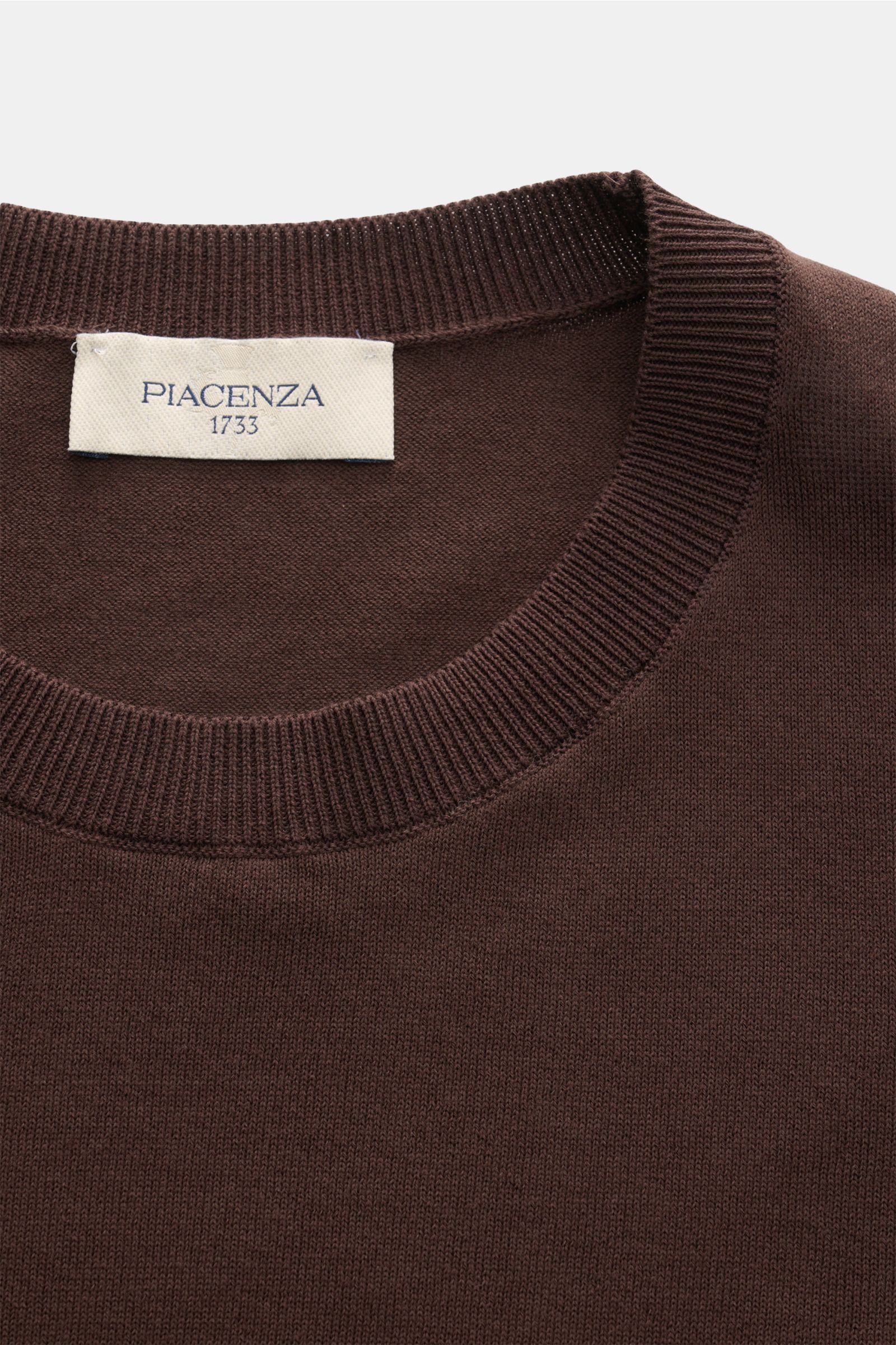 Nahaufnahme des Piacenza 1733 Kurzarmpullovers dunkelbraun, von oben fotografiert, mit feinem, offenem Strickbild aus reiner Baumwolle, Slim Fit und flexiblen Rippbündchen, ideal für die Sommersaison.