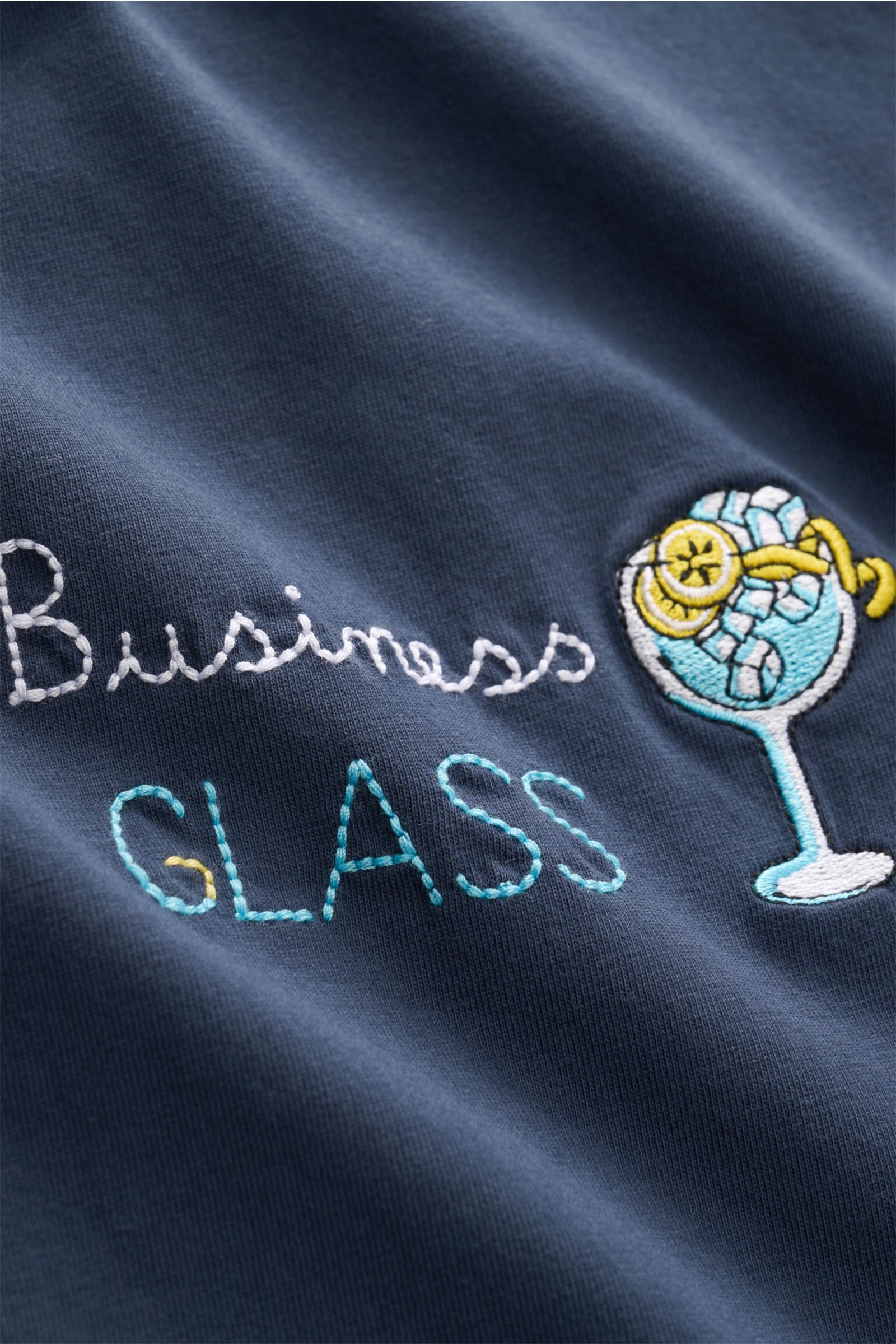 Close-up front view of MC2 Saint Barth Crew neck T-shirt 'Portofino' navy showing detailed chest stitching with 'Business Glass' text and cocktail embroidery.

Summery and eye-catching: This T-shirt by MC2 SAINT BARTH, made from soft organic cotton, fe