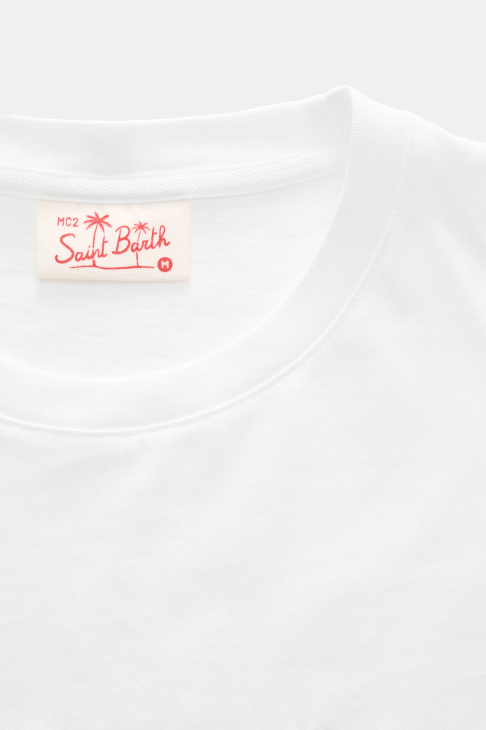 Alt tag (125 characters): Close-up from above of MC2 Saint Barth Rundhals-T-Shirt 'Portofino' weiß neckline with logo label in red print.

Description: Sommerlicher Hingucker: Das T-Shirt von MC2 SAINT BARTH aus weicher Bio-Baumwolle wird mit auffällig