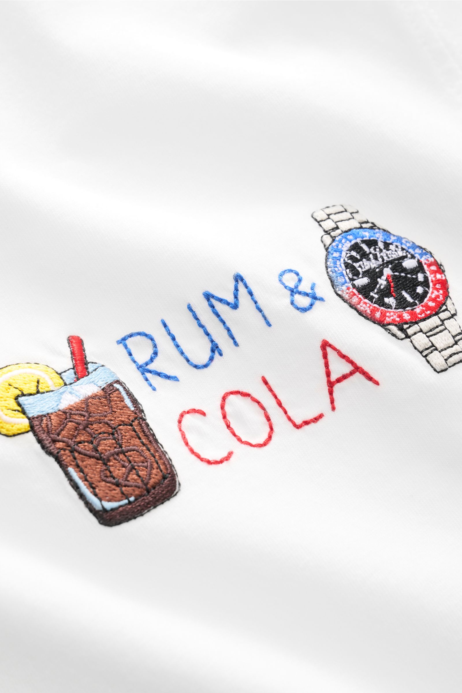 Close-up front view of MC2 Saint Barth Rundhals-T-Shirt 'Portofino' weiß showing detailed colorful embroidery of a watch and drinks on soft white organic cotton.

Sommerlicher Hingucker: Das T-Shirt von MC2 SAINT BARTH aus weicher Bio-Baumwolle wird mi