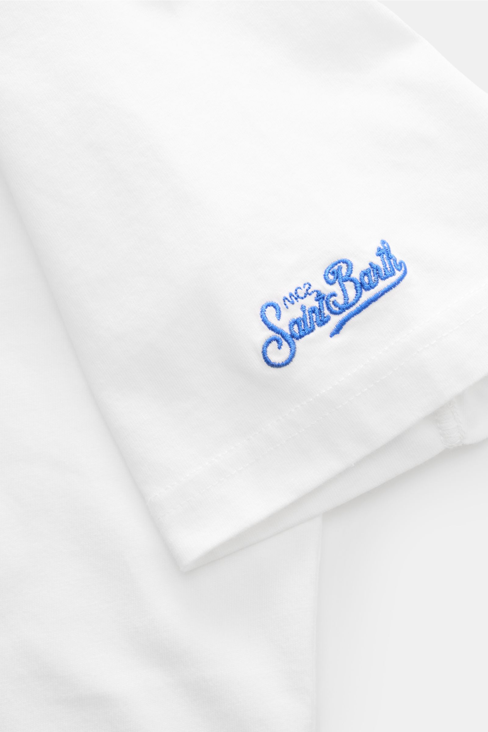 Close-up side view of the sleeve of the MC2 Saint Barth Rundhals-T-Shirt 'Portofino' weiß, showing blue St. Barth embroidery on soft white organic cotton.

Sommerlicher Hingucker: Das T-Shirt von MC2 SAINT BARTH aus weicher Bio-Baumwolle wird mit auffä
