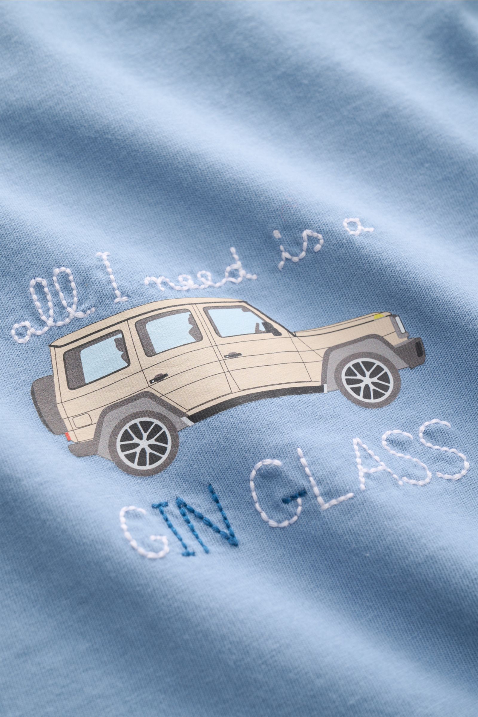 Close-up front view of the MC2 Saint Barth Crew neck T-shirt 'Portofino' smoky blue, showing detailed chest stitching and print of a beige car with text.

Description: Summery and eye-catching: This MC2 SAINT BARTH T-shirt, made from soft organic cotto
