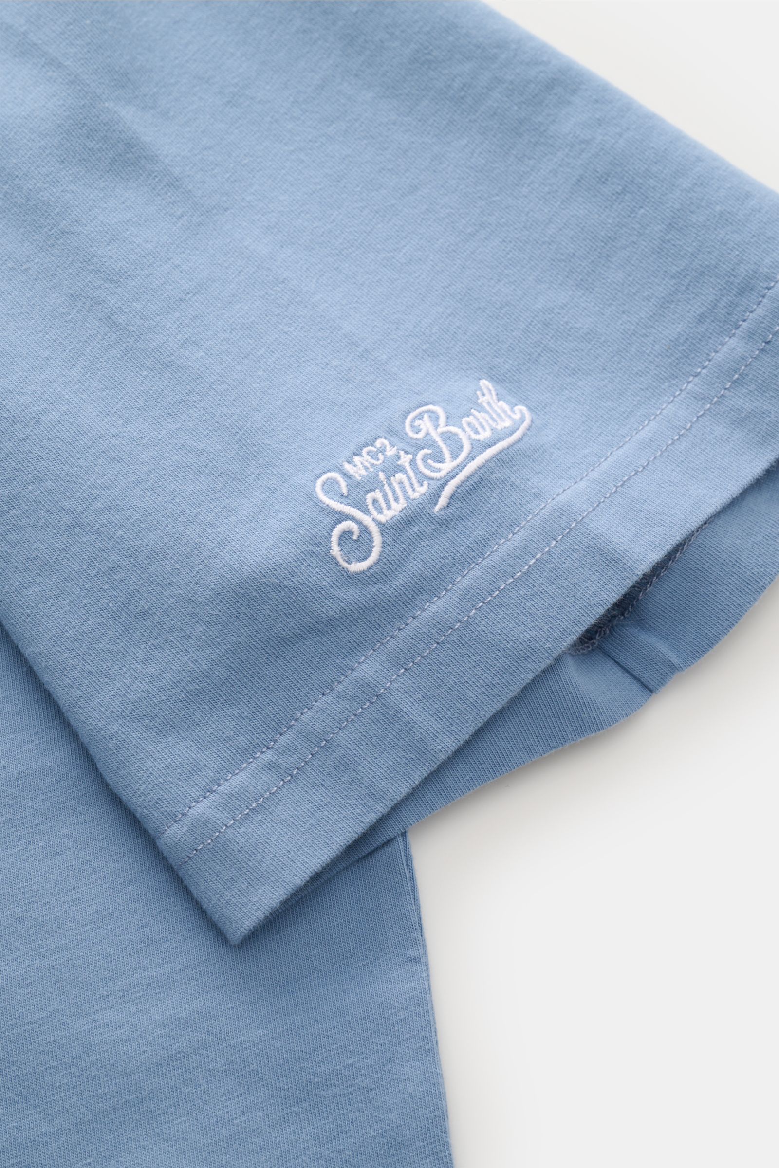 Close-up side view of MC2 Saint Barth Crew neck T-shirt 'Portofino' smoky blue sleeve with white St. Barth embroidery on soft organic cotton fabric.

Description: Summery and eye-catching: This MC2 SAINT BARTH T-shirt, made from soft organic cotton, fe