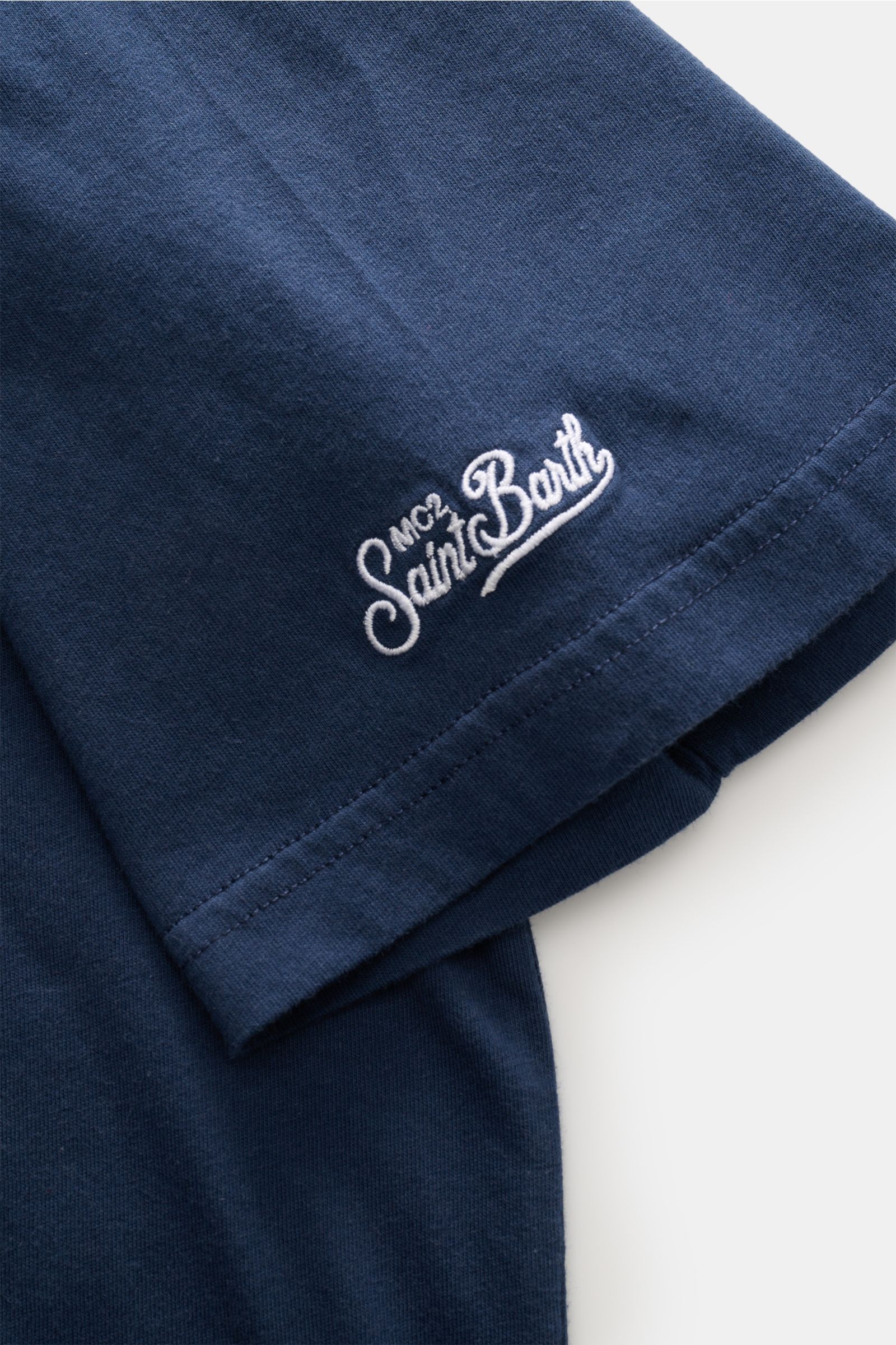 Close-up side view of the navy MC2 Saint Barth Rundhals-T-Shirt 'Portofino' showing soft organic cotton fabric and white St. Barth embroidery on the sleeve.

Sommerlicher Hingucker: Das T-Shirt von MC2 SAINT BARTH aus weicher Bio-Baumwolle wird mit Sti