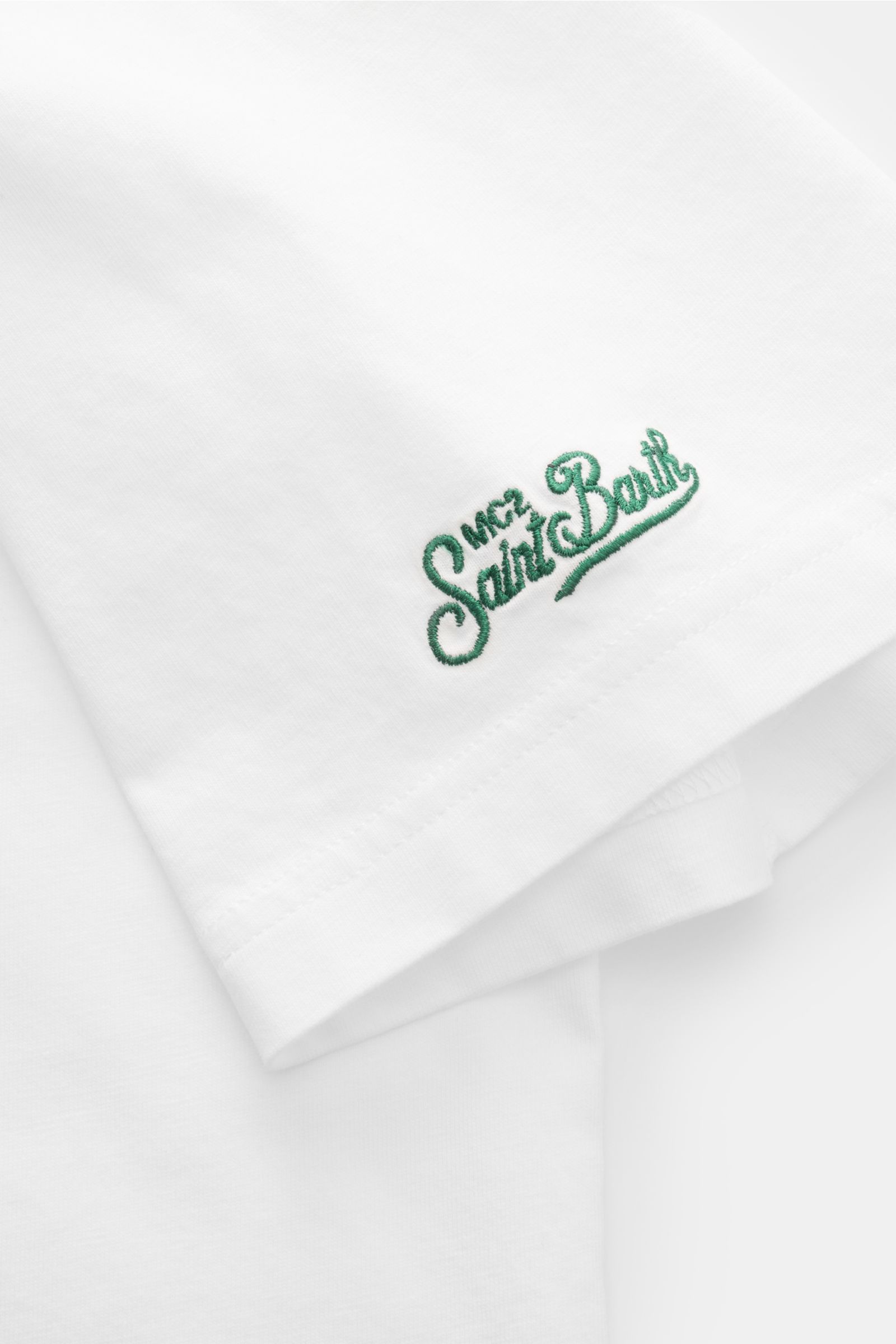 Close-up front-side view of the MC2 Saint Barth 'Portofino' crew neck T-shirt white showing green St. Barth embroidery on the sleeve.

Summery and eye-catching: This T-shirt by MC2 SAINT BARTH, made from soft organic cotton, features eye-catching stitc